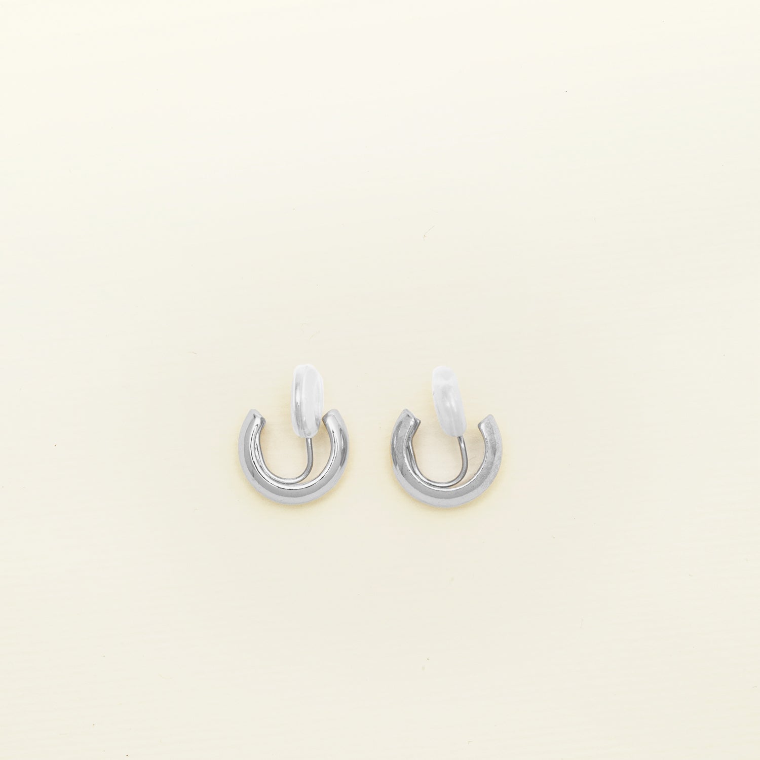 Image of the Simple Silver Huggie Clip-On Earrings provide a medium secure hold, making them perfect for all ear types. With adjustable padding for extra comfort, these earrings can be worn for up to 24 hours with ease. 