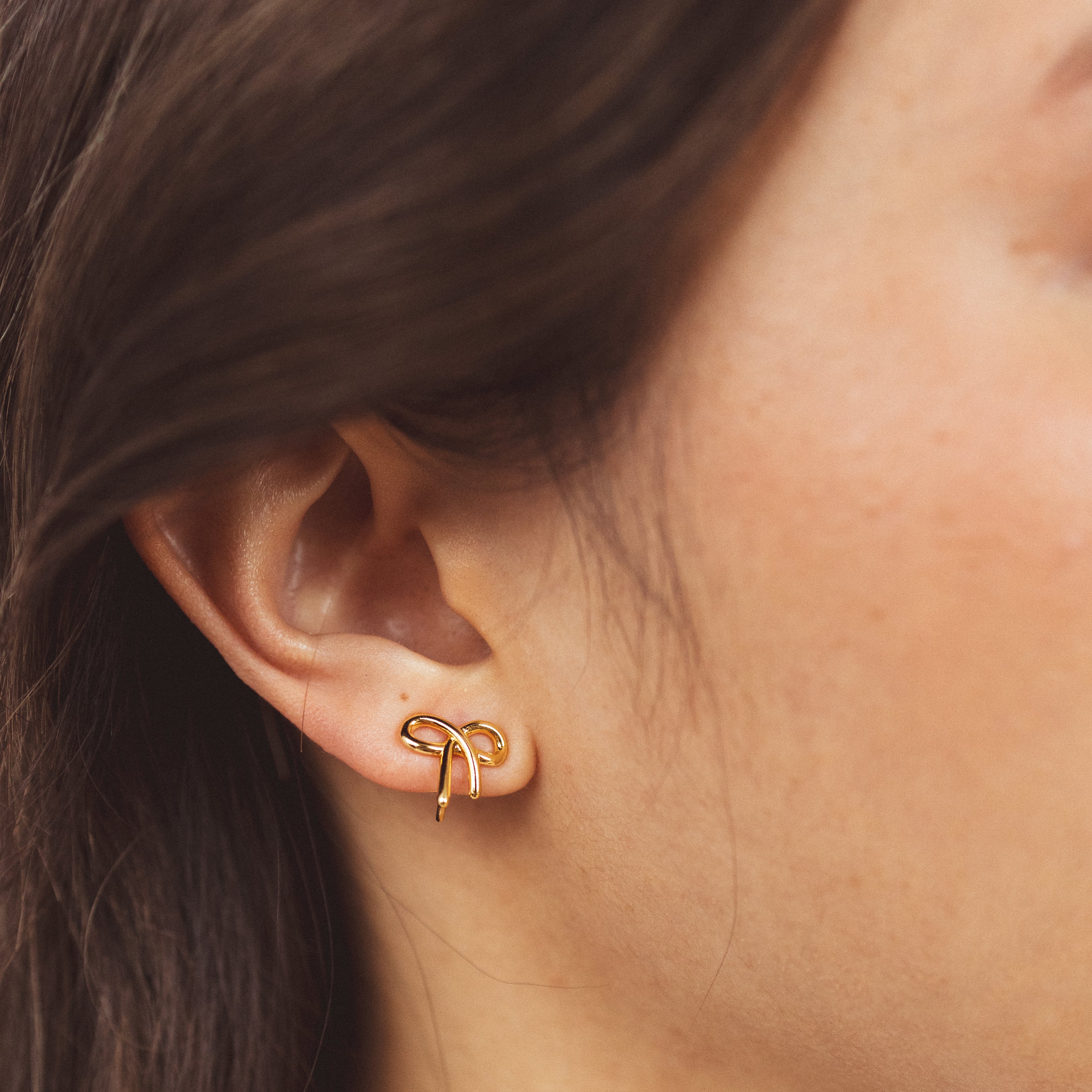A model wearing the Alice Clip On Earrings. With a special mosquito coil clip-on design, these earrings fit all ear types, from thick and sensitive to small and keloid prone. Enjoy 24 hours of comfortable wear and a medium secure hold, perfect for all-day wear.