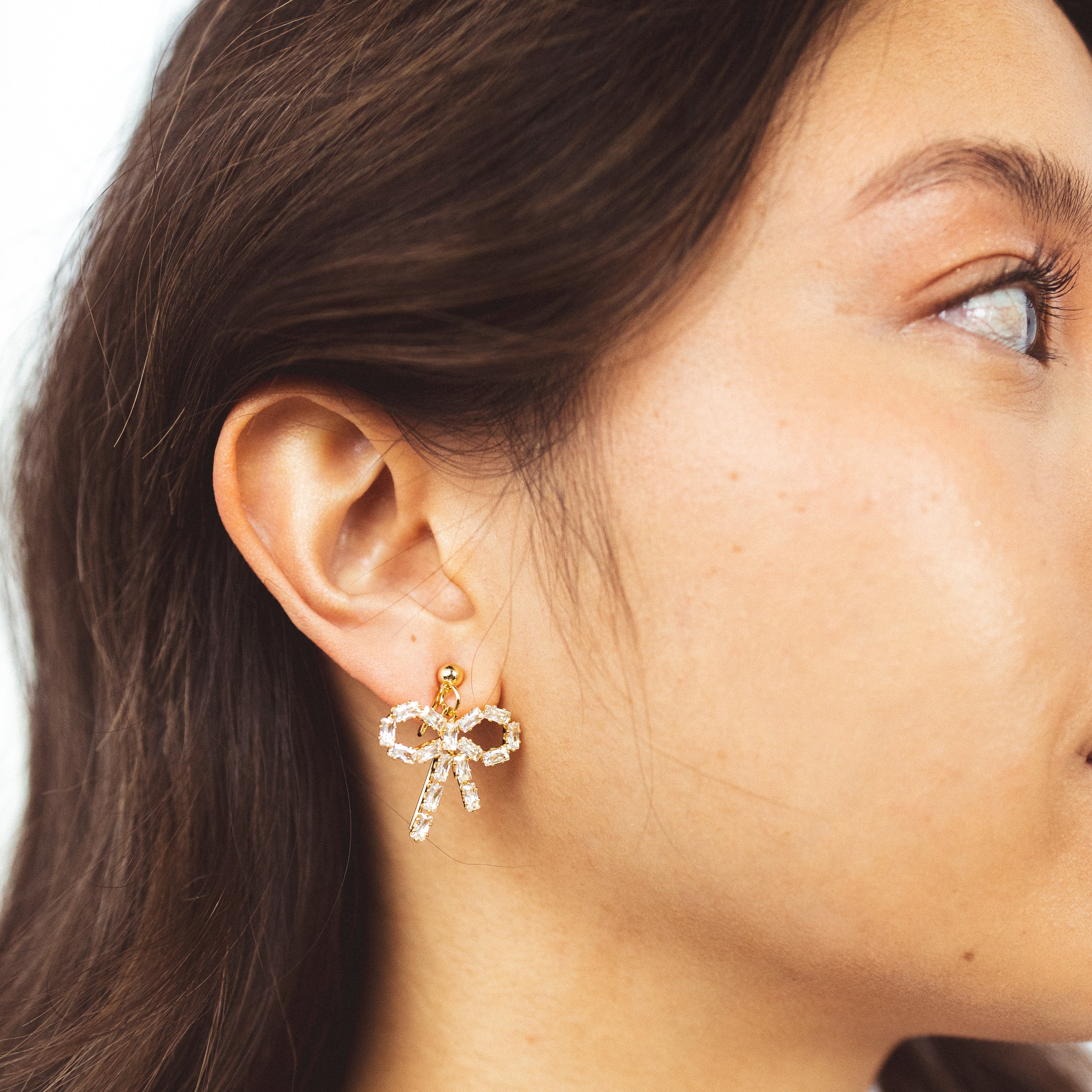 A model wearing the Jane Clip On Earrings! These stylish and versatile earrings are perfect for non-pierced ears, featuring a secure hold for up to 24 hours. With an adjustable fit and suitability for sensitive or stretched ears, they're the perfect accessory for any occasion.