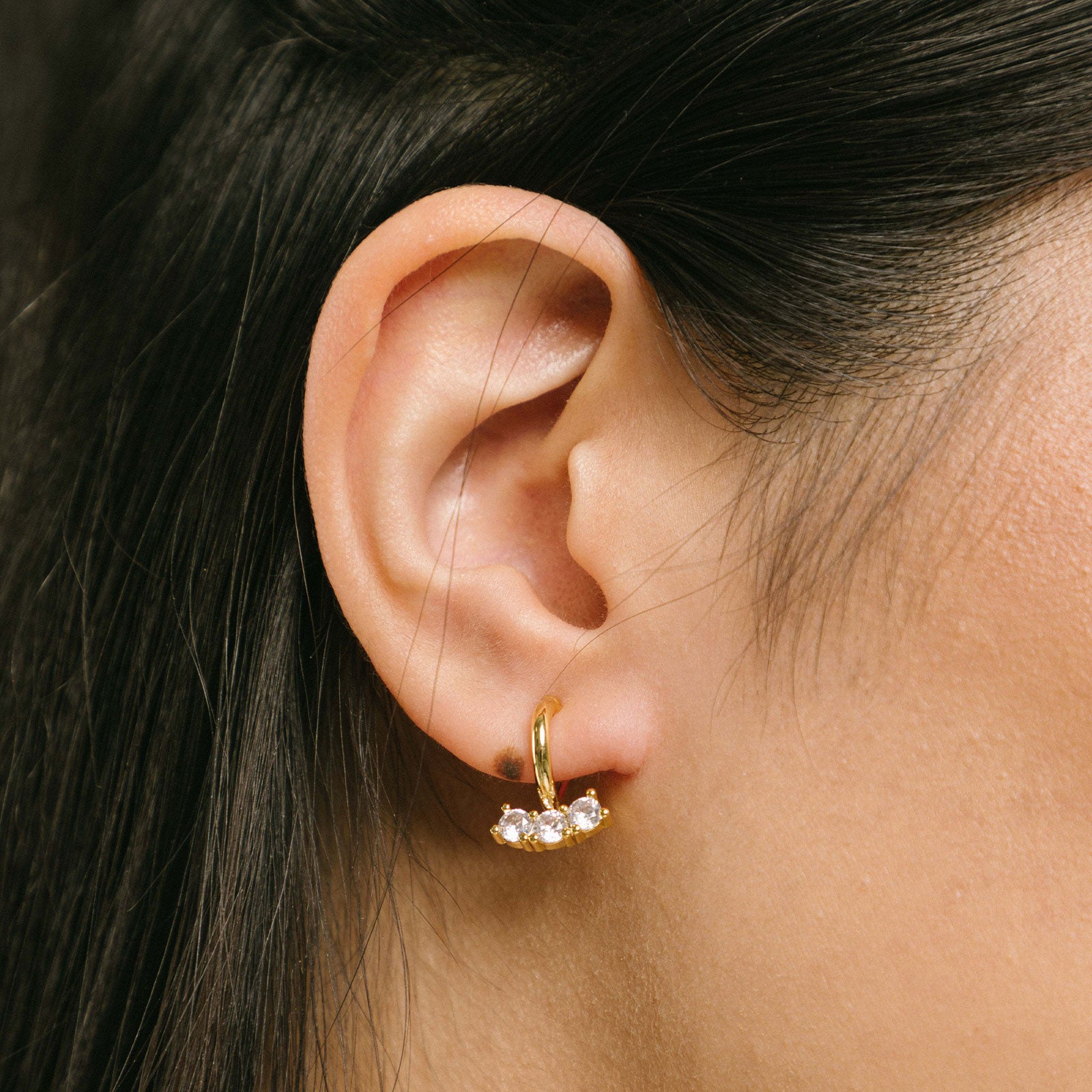 A model wearing the Juliette Clip-On Earrings offer a medium-strength, secure hold that lasts 24 hours. Easily adjustable with a gentle squeeze, these Mosquito Coil Clip-Ons are ideal for thick/large ears as well as sensitive ears. Crafted with gold-tone plated metal alloy and cubic zirconia, this item is sold as a single pair.