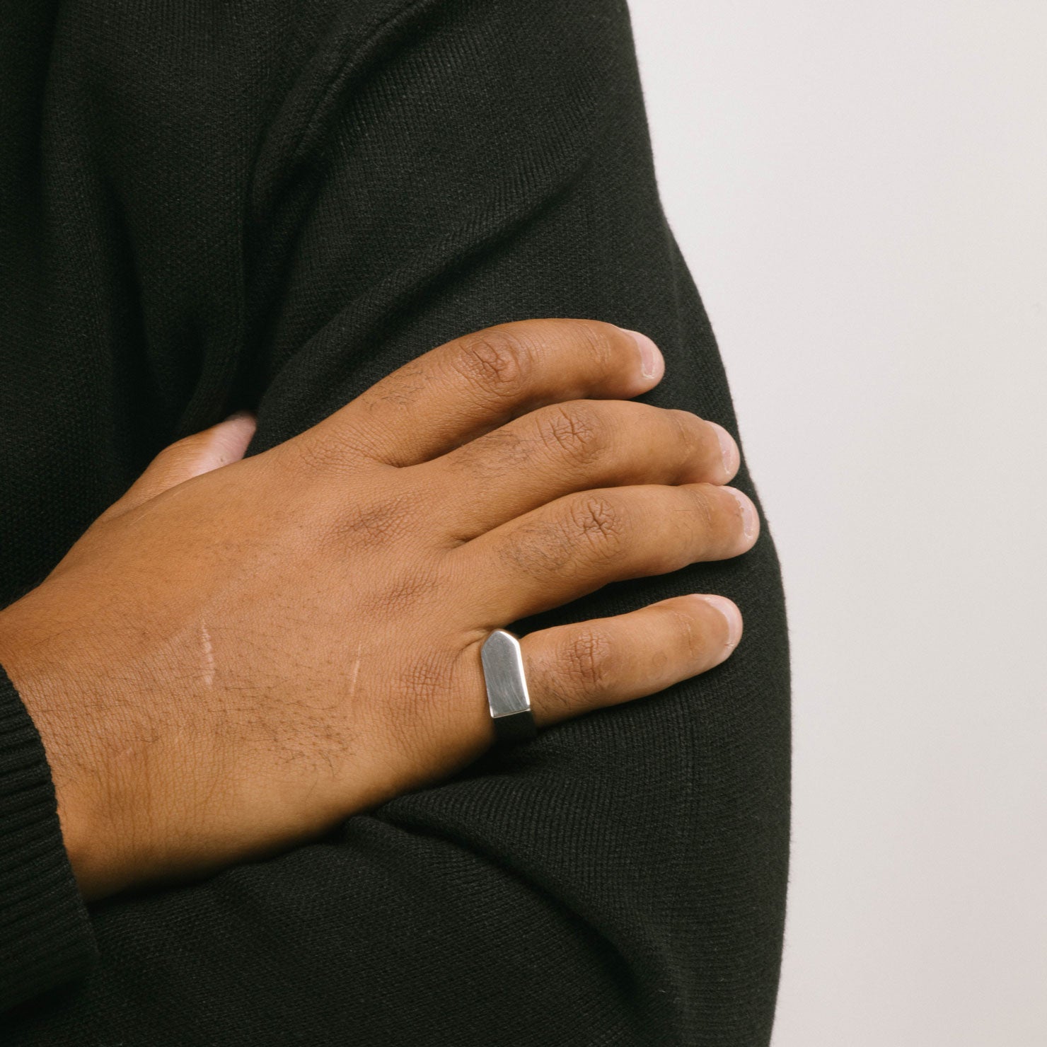 A model wearing the Pointed Band Ring in Silver is made using stainless steel and has a width of 8mm. Its superior construction provides lasting durability and protection from water damage and tarnishing.