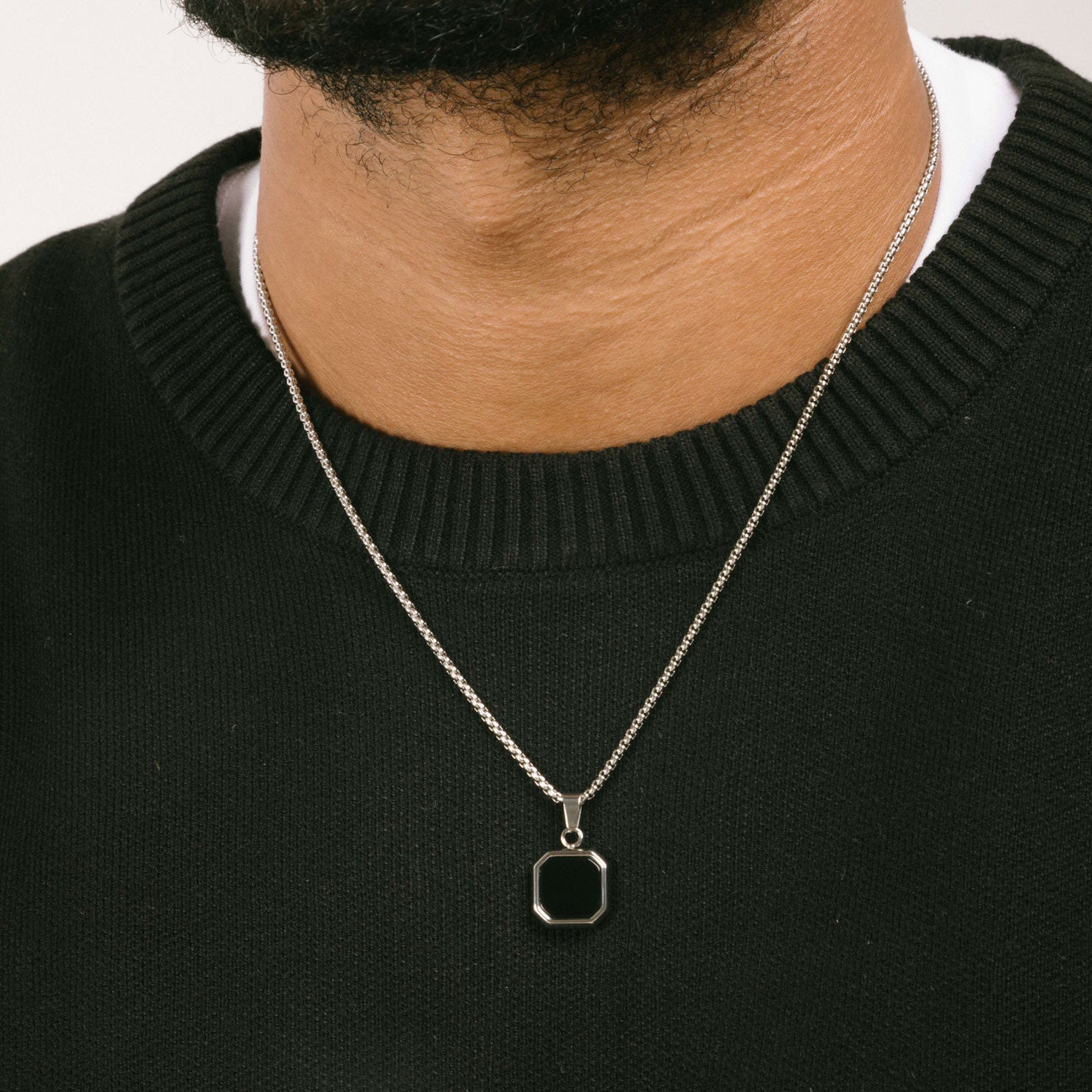 A model wearing the Square Signet Pendant Chain is crafted from durable stainless steel, providing reliable wear and tear resistance. It's also non-tarnish, water resistant, and free of lead, nickel, and cadmium.