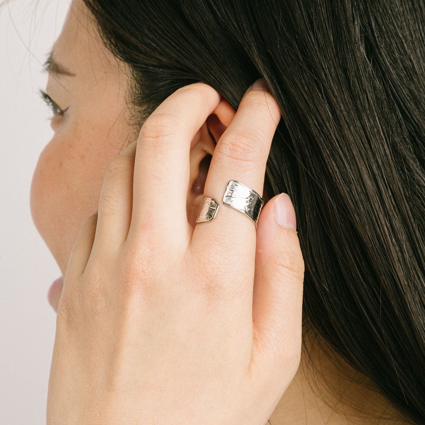 A model wearing the Textured Curl Ring in Silver offers adjustable sizing between 7-10, while crafted with stainless steel for long-lasting use. It is also water-resistant, non-tarnishing, and free of lead, nickel, and cadmium. Note: this is a single ring.