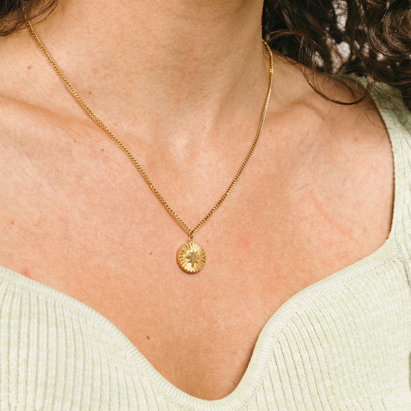 A model wearing the Starlight Pendant Necklace is adjustable, inspiring guidance and protection. This necklace is part of the Celestial Collection and pairs nicely with the Celestial Light Pendant Necklace. Constructed with 18K gold plating on 316L stainless steel, this piece is waterproof and resistant to tarnishing.