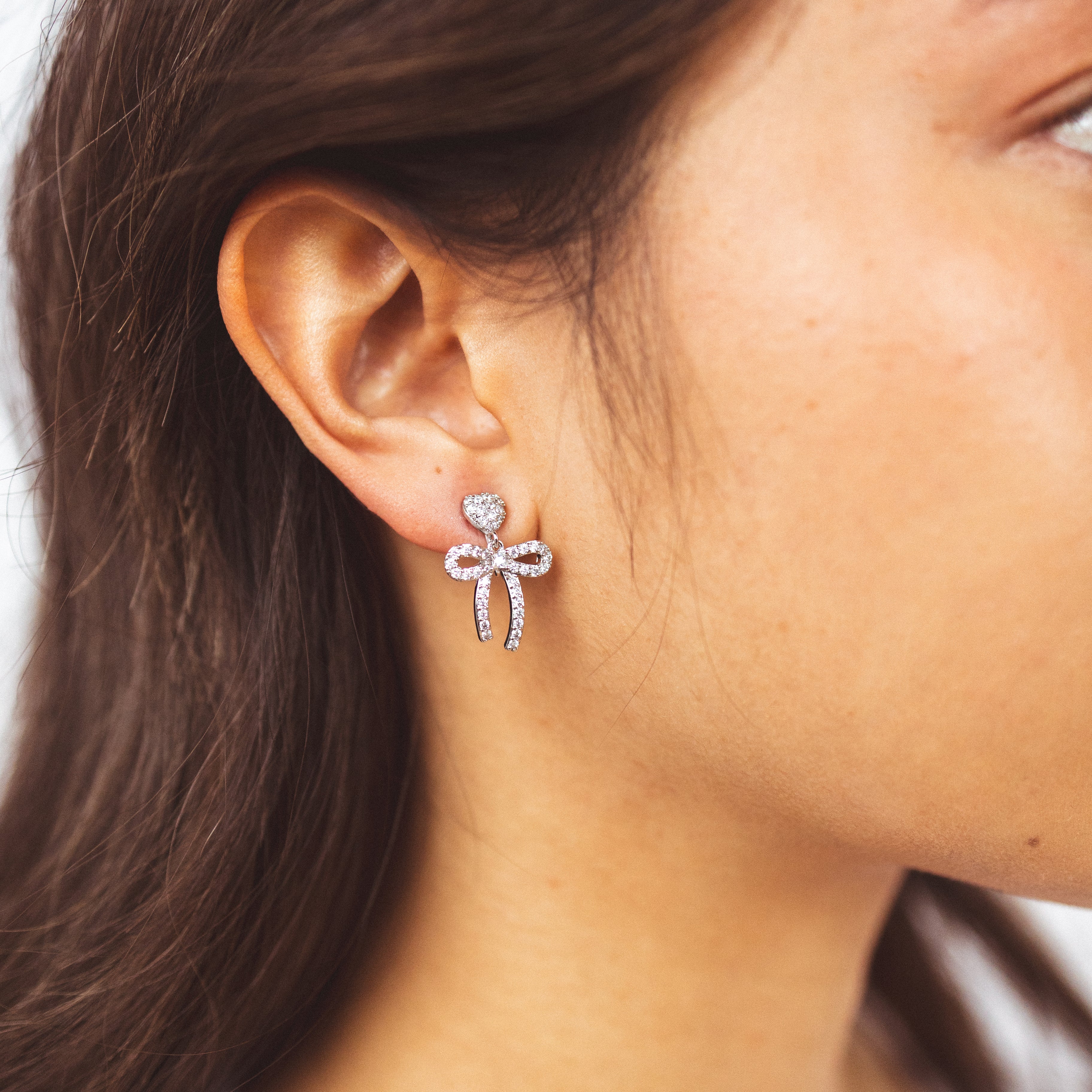 A model wearing the Lara Clip On Earrings. With a secure hold for up to 24 hours, these versatile and stylish earrings are suitable for all ear types and easily adjustable. Perfect for sensitive or stretched ears, they provide medium strength for a comfortable and hassle-free experience.