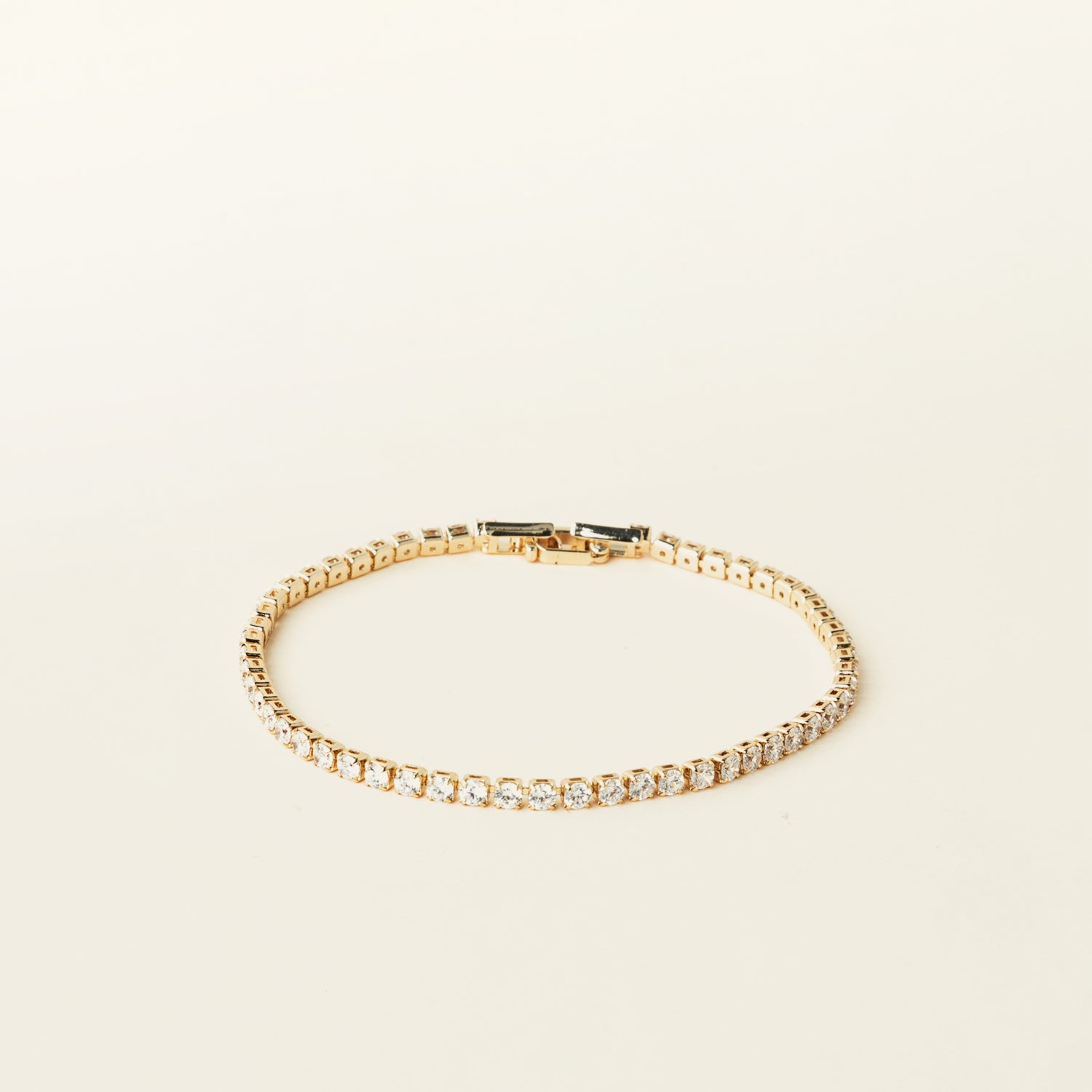 Image of the Tennis Bracelet is an exquisite companion to its sister piece, the Classic Tennis Necklace. Meticulously constructed from 14K gold plated metal, it is embellished with shimmering Cubic Zirconia stones. Additionally, its design is exceptionally enduring - it is tarnish-resistant, water-resistant, nickel-free, and hypoallergenic.