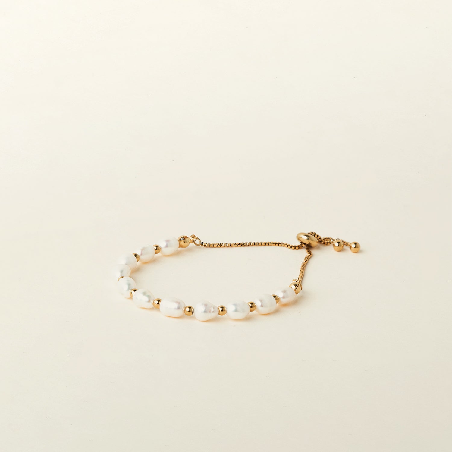 Image of the Emi Pearl Bracelet is crafted from 18K Gold Plated Stainless Steel and Freshwater Pearls, allowing for a small degree of variation in size and hue. The bracelet is water-resistant and hypoallergenic.