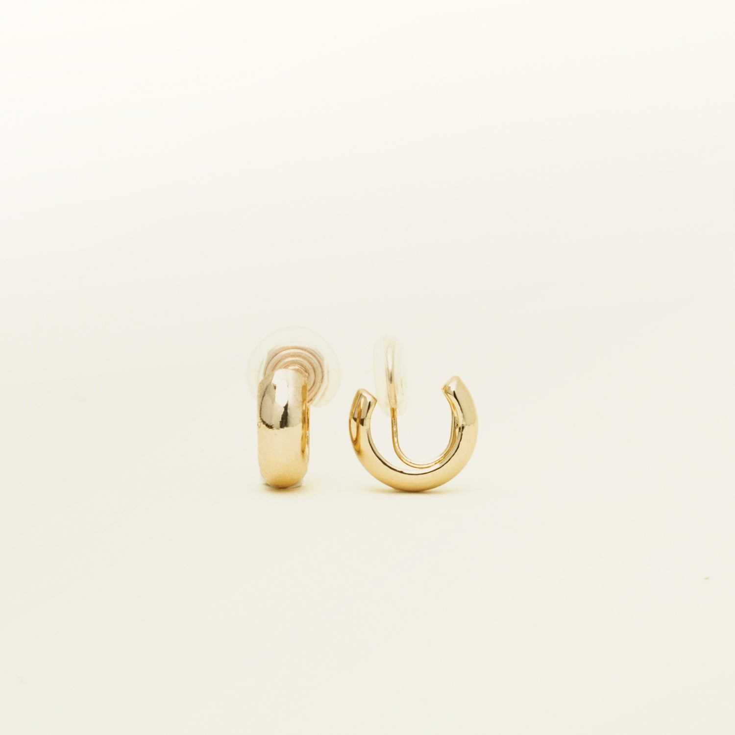 Image of the Small Hoop Clip On Earrings in Gold feature a mosquito coil closure for a secure hold of up to 24 hours. The earrings are designed to fit any ear type, including thick or large, sensitive, small or thin, and stretched or healing ears. They possess a medium secure hold and can be adjusted to fit the wearer's ear size, simply by gently squeezing the inner padding forward. Crafted from gold tone plated copper alloy, each package contains one pair.