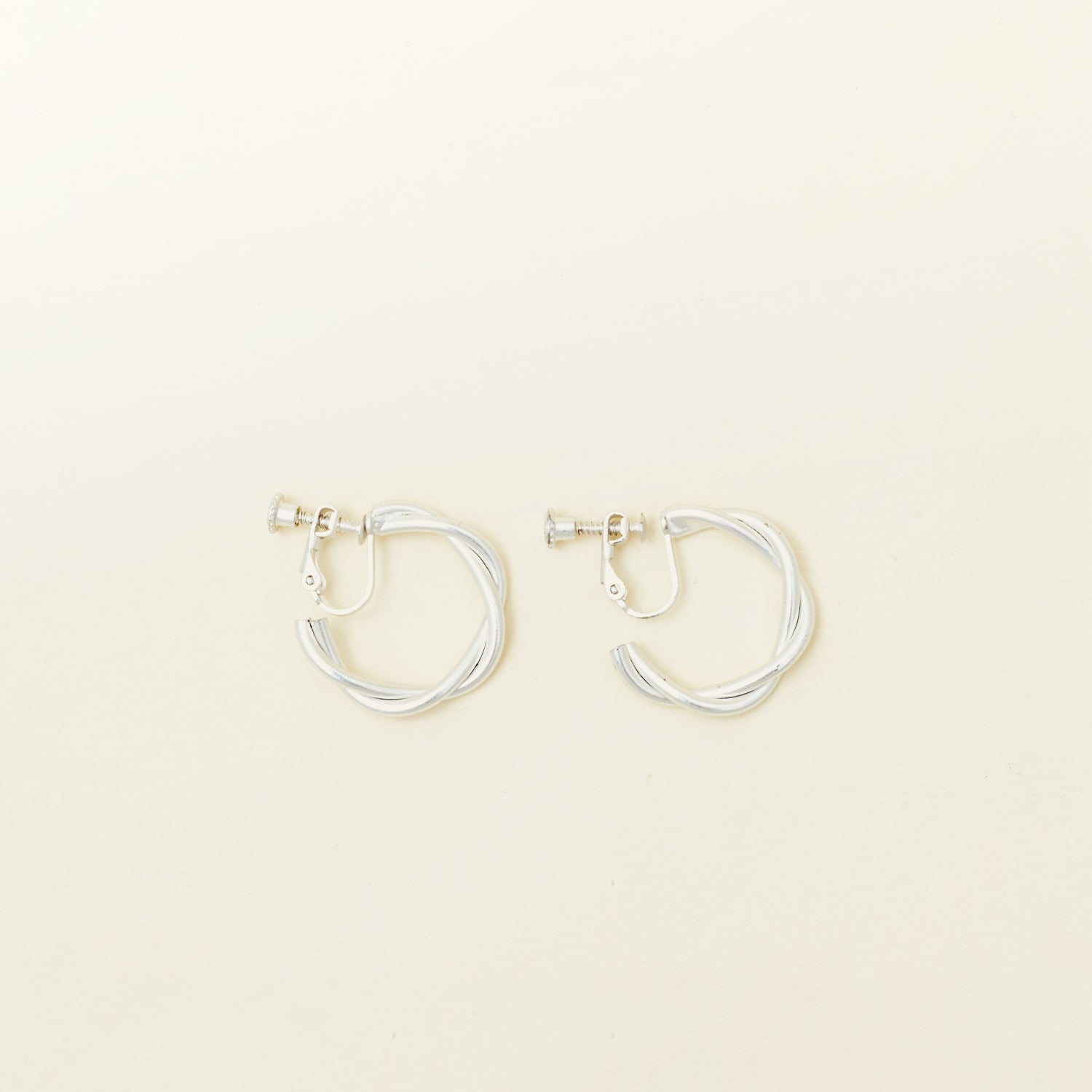 Image of the Twist Hoop Earrings feature a secure and comfortable screwback clip-on closure ideal for all ear types. 