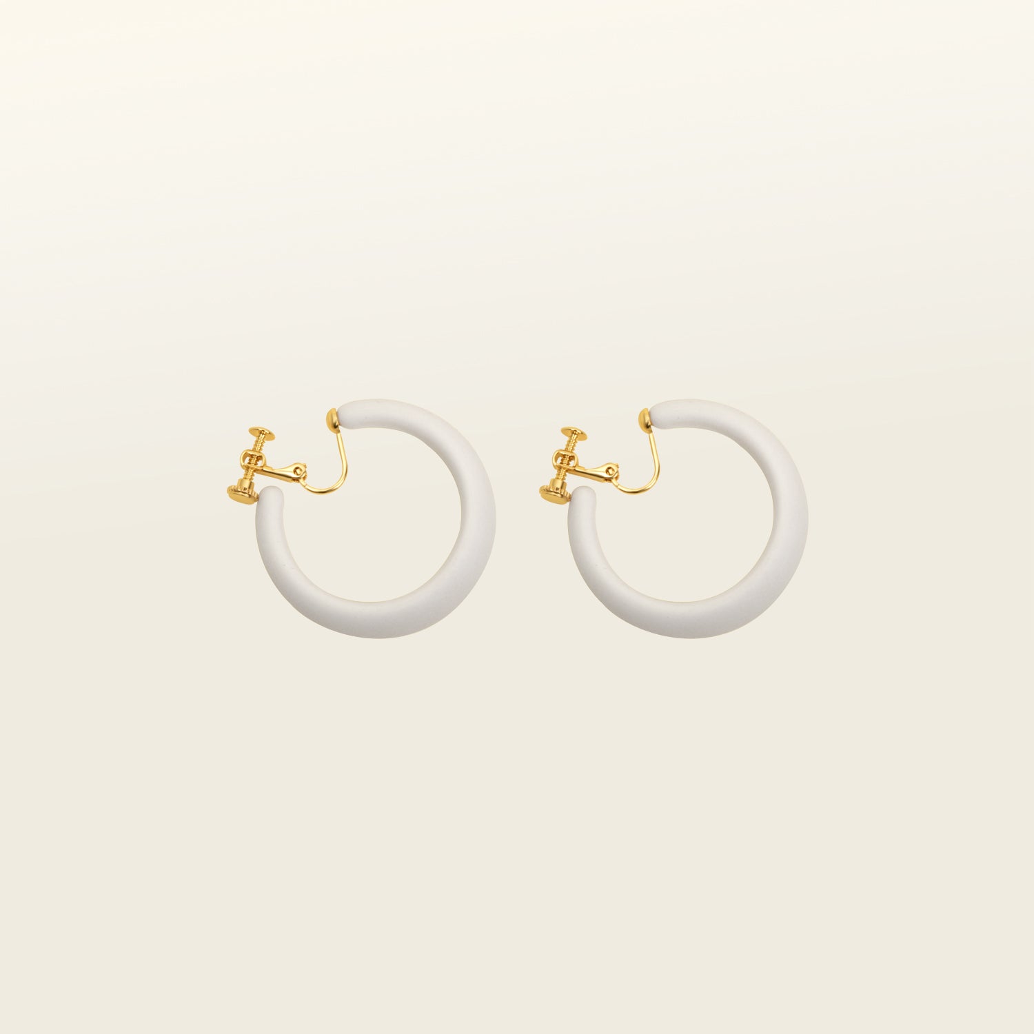 Modern white clip-on earrings featuring a secure screwback closure, suitable for various ear types. These earrings can be manually adjusted for a personalized fit. Crafted from gold tone copper metal alloy and acrylic.