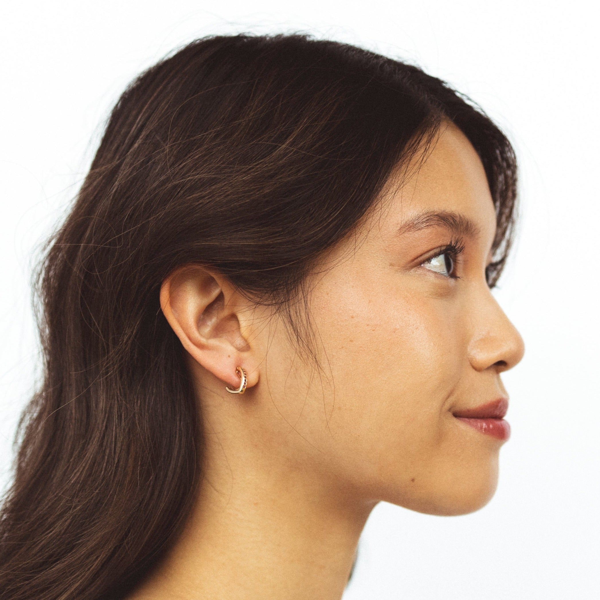 A model wearing the Alex Clip On Earrings. These versatile earrings offer a comfortable, secure 24-hour hold and adjustable fit for all ear types. Perfect for sensitive or stretched ears, they add a touch of elegance to any look.