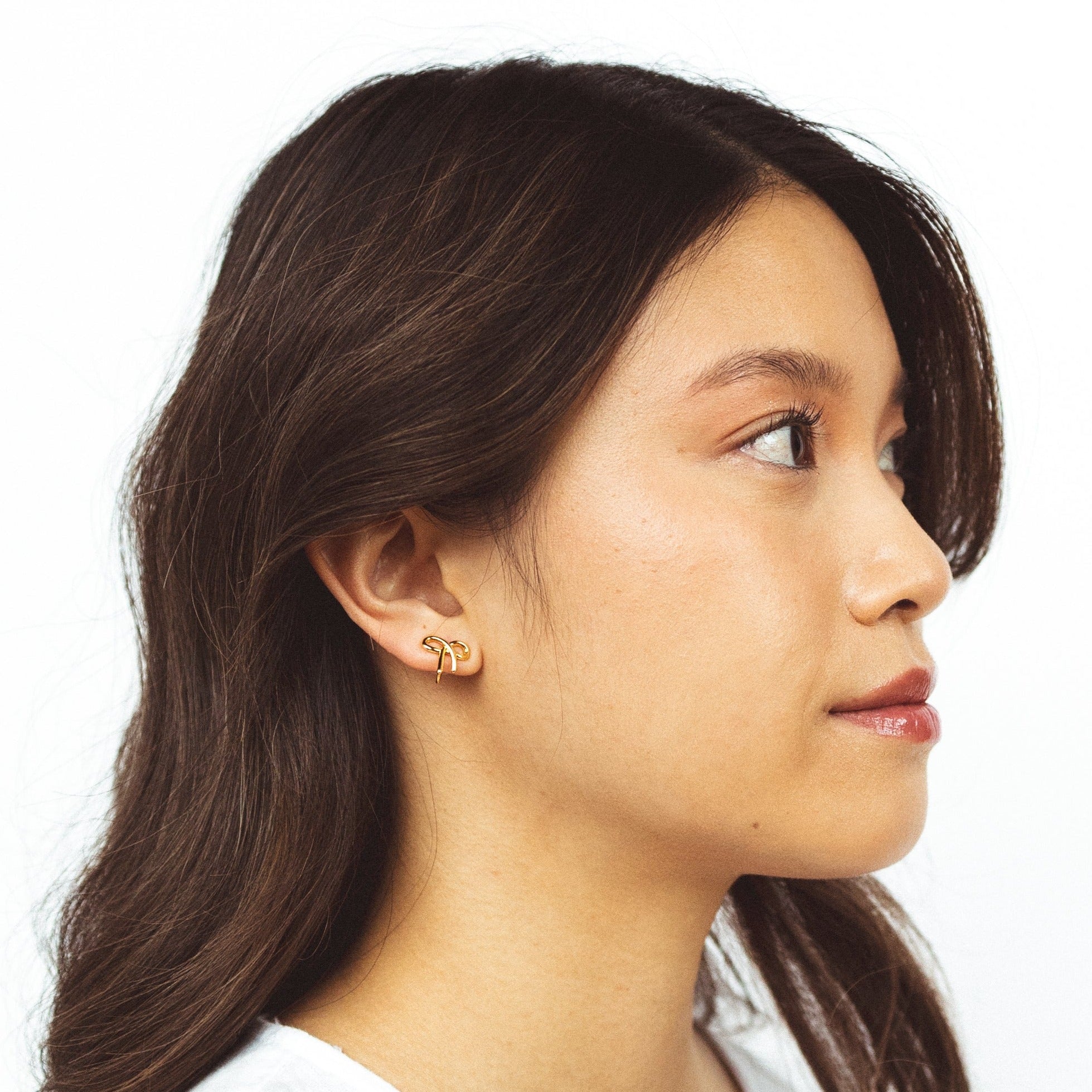 A model wearing the Alice Clip On Earrings. With a special mosquito coil clip-on design, these earrings fit all ear types, from thick and sensitive to small and keloid prone. Enjoy 24 hours of comfortable wear and a medium secure hold, perfect for all-day wear.