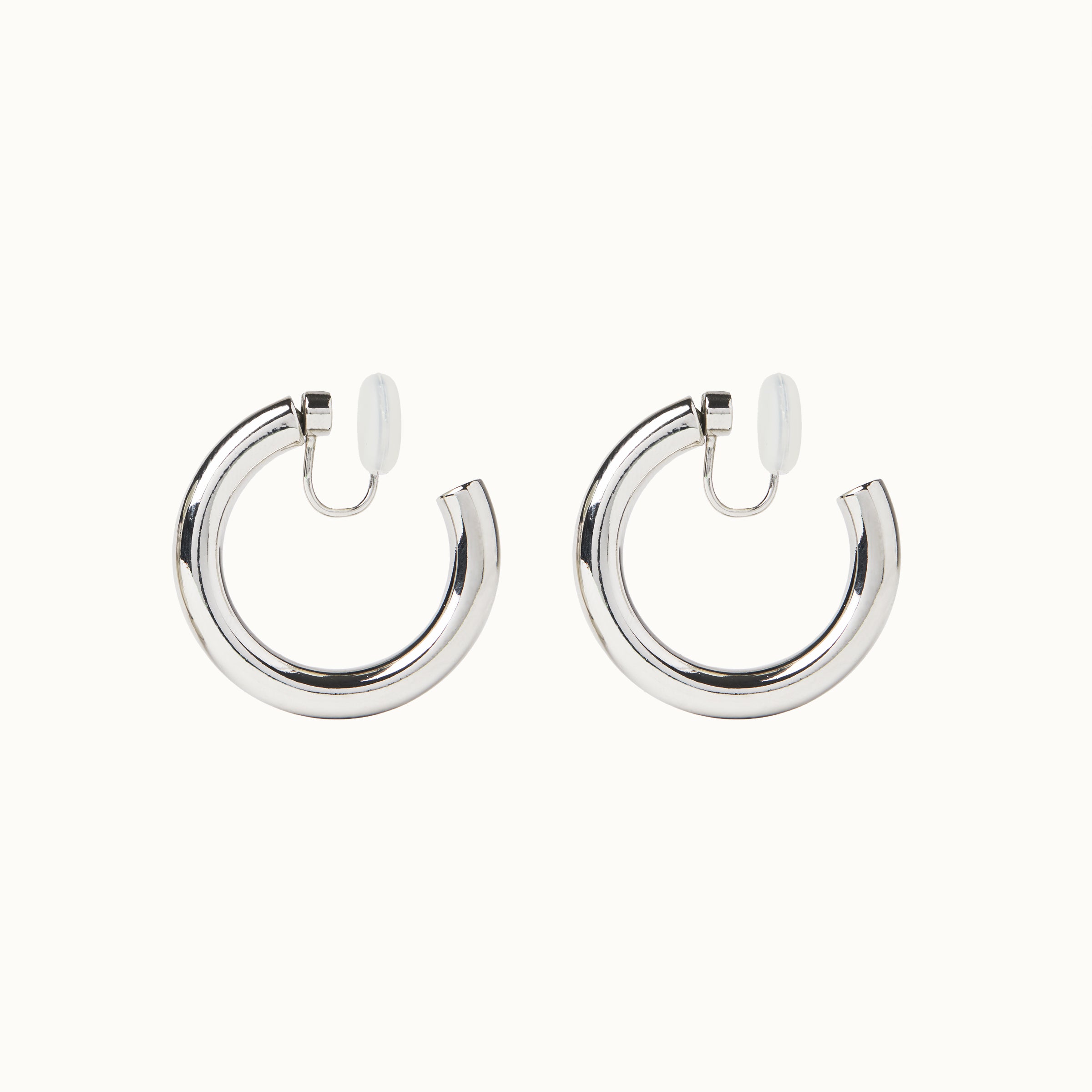 Image of the Allie Hoop Clip On Earrings in Silver, which are perfect for all ear types. The Mosquito Coil Clip-On Closure is suitable for Thick/Large, Sensitive, Small/Thin, Stretched/Healing, and Keloid Prone Ears. Made of a silver tone copper alloy, each purchase includes one pair.