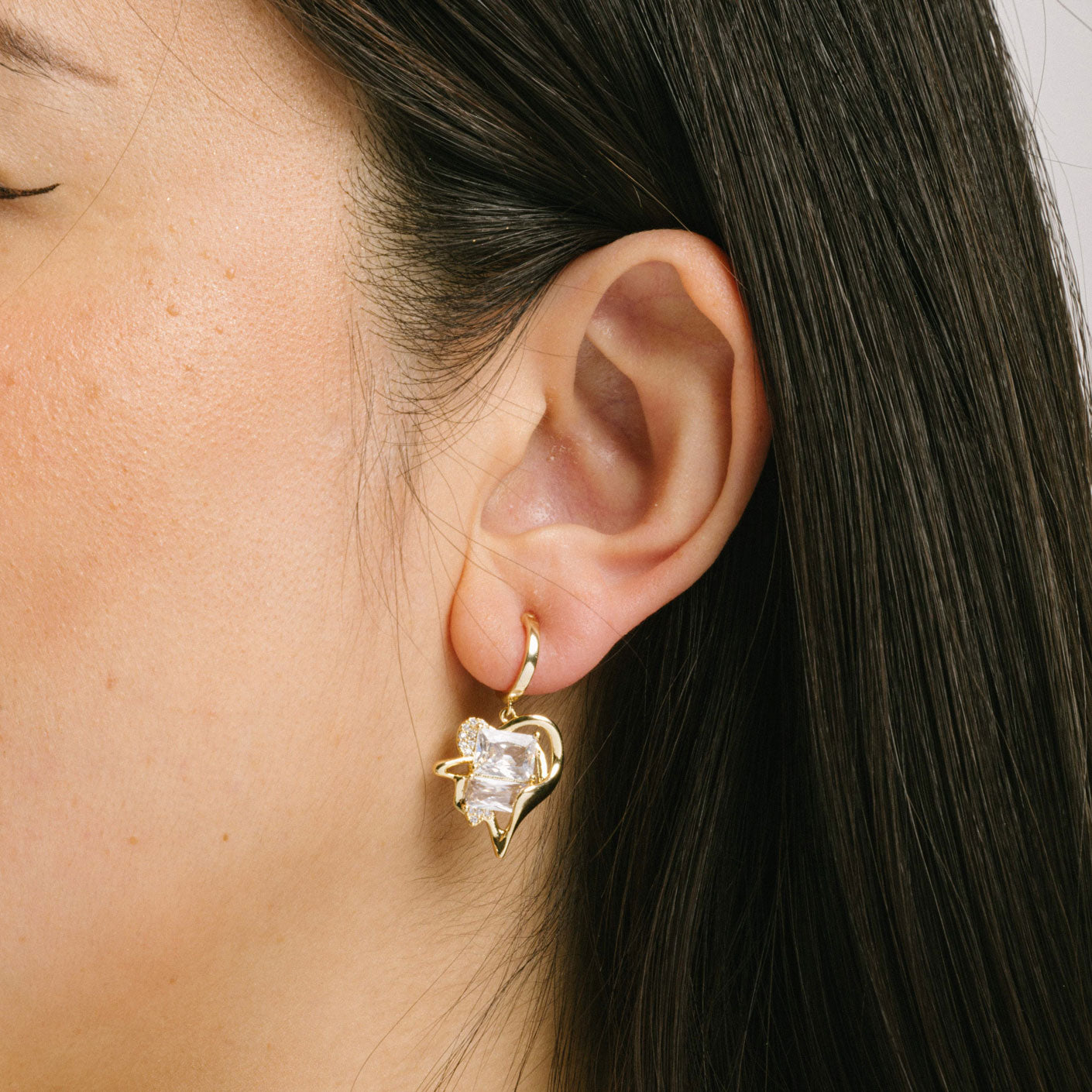 A model wearing the Amaretto Clip On Earrings feature a Mosquito Coil Clip-On closure type, making them ideal for all ear types, from Thick/Large Ears to Sensitive ones and Small/Thin Ears to Stretched/Healing Ears. Average wear duration can be up to 24 hours with a medium secure hold, and they can be gently adjusted by squeezing the padding forward once on the ear. The materials used in their construction areCubic Zirconia and Copper. Please note, item is only one pair.