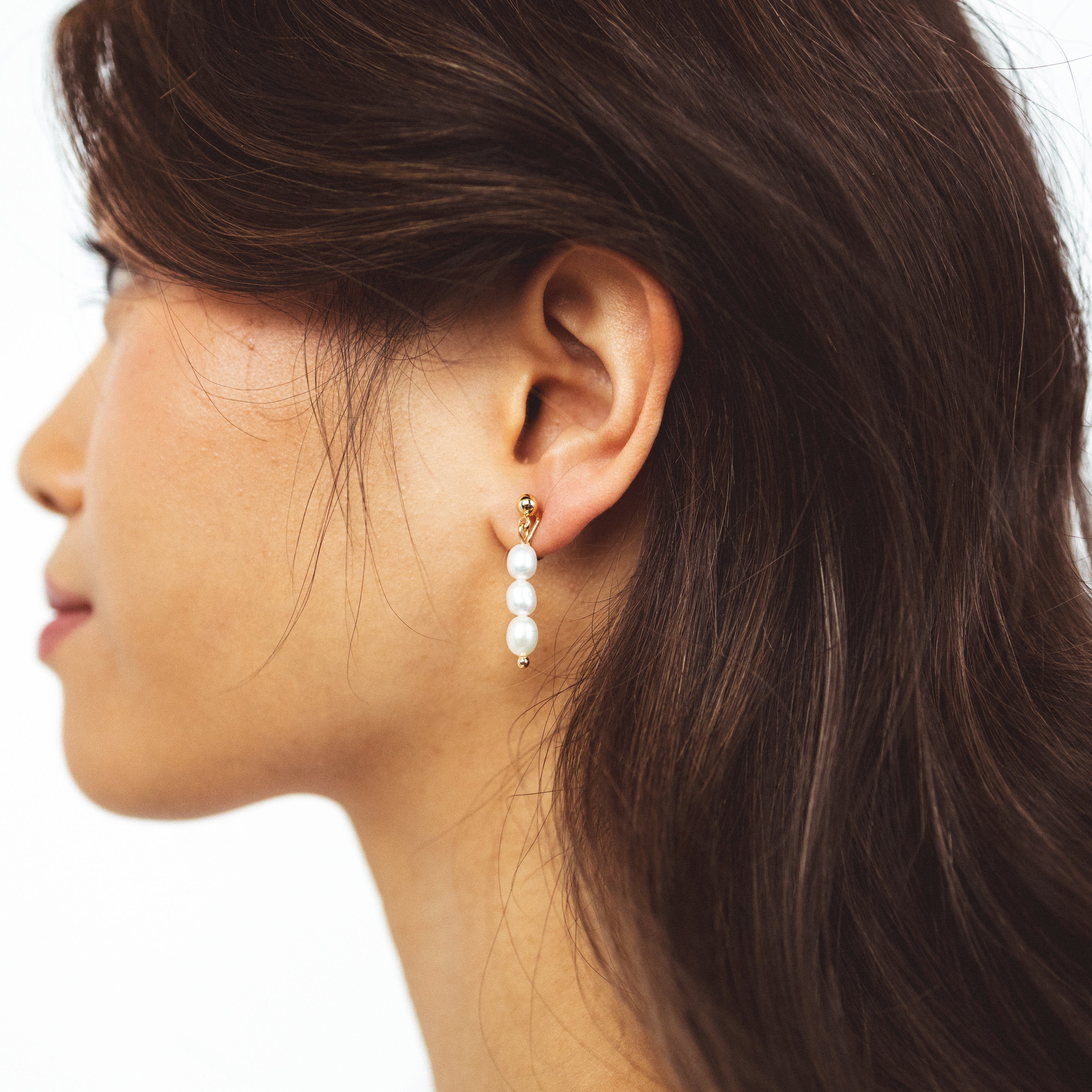 A model wearing the Audrey Clip On Earrings. These elegant earrings are adjustable for any ear type and provide a secure and comfortable hold for up to 24 hours. Perfect for sensitive or stretched ears, add a touch of sophistication to your daily style.