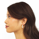 A model wearing the Audrey Clip On Earrings. These elegant earrings are adjustable for any ear type and provide a secure and comfortable hold for up to 24 hours. Perfect for sensitive or stretched ears, add a touch of sophistication to your daily style.