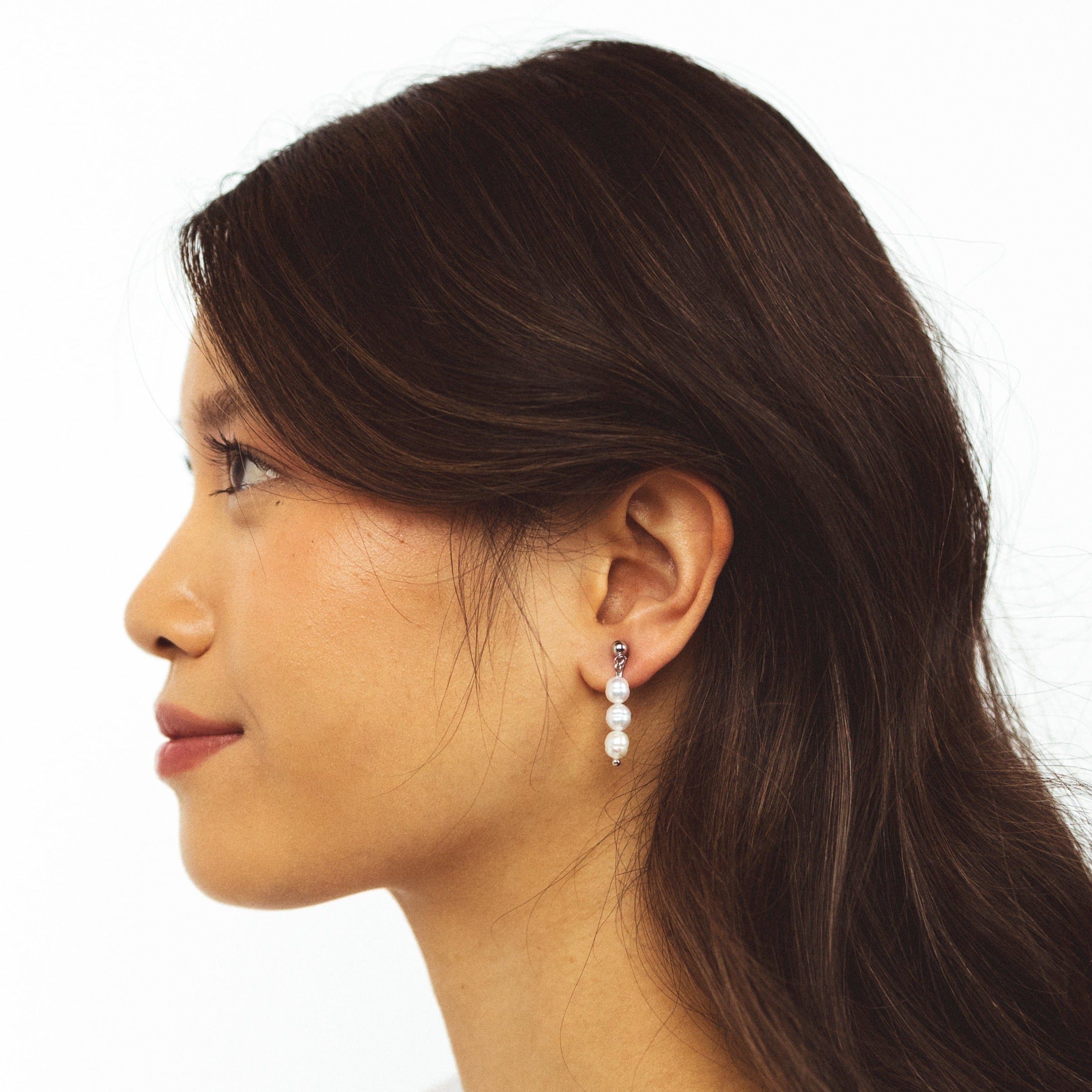 A model wearing the Audrey Clip On Earrings. These elegant earrings are adjustable for any ear type and provide a secure and comfortable hold for up to 24 hours. Perfect for sensitive or stretched ears, add a touch of sophistication to your daily style.
