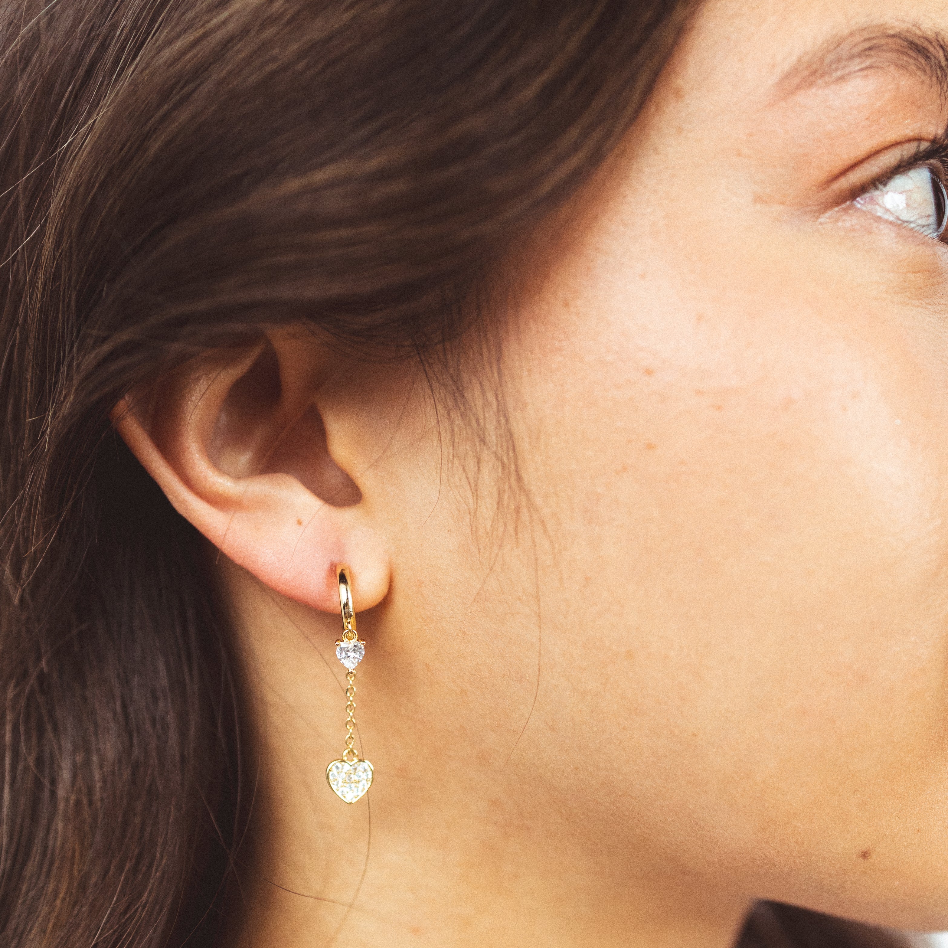 A model wearing the Aurora Clip on Earrings offer versatility with a Mosquito Coil Clip-On Closure that accommodates different ear types, including Thick, Sensitive, Small, Stretched, and Keloid Prone ears. Its Medium hold strength and adjustable padding provide a comfortable fit for any occasion.