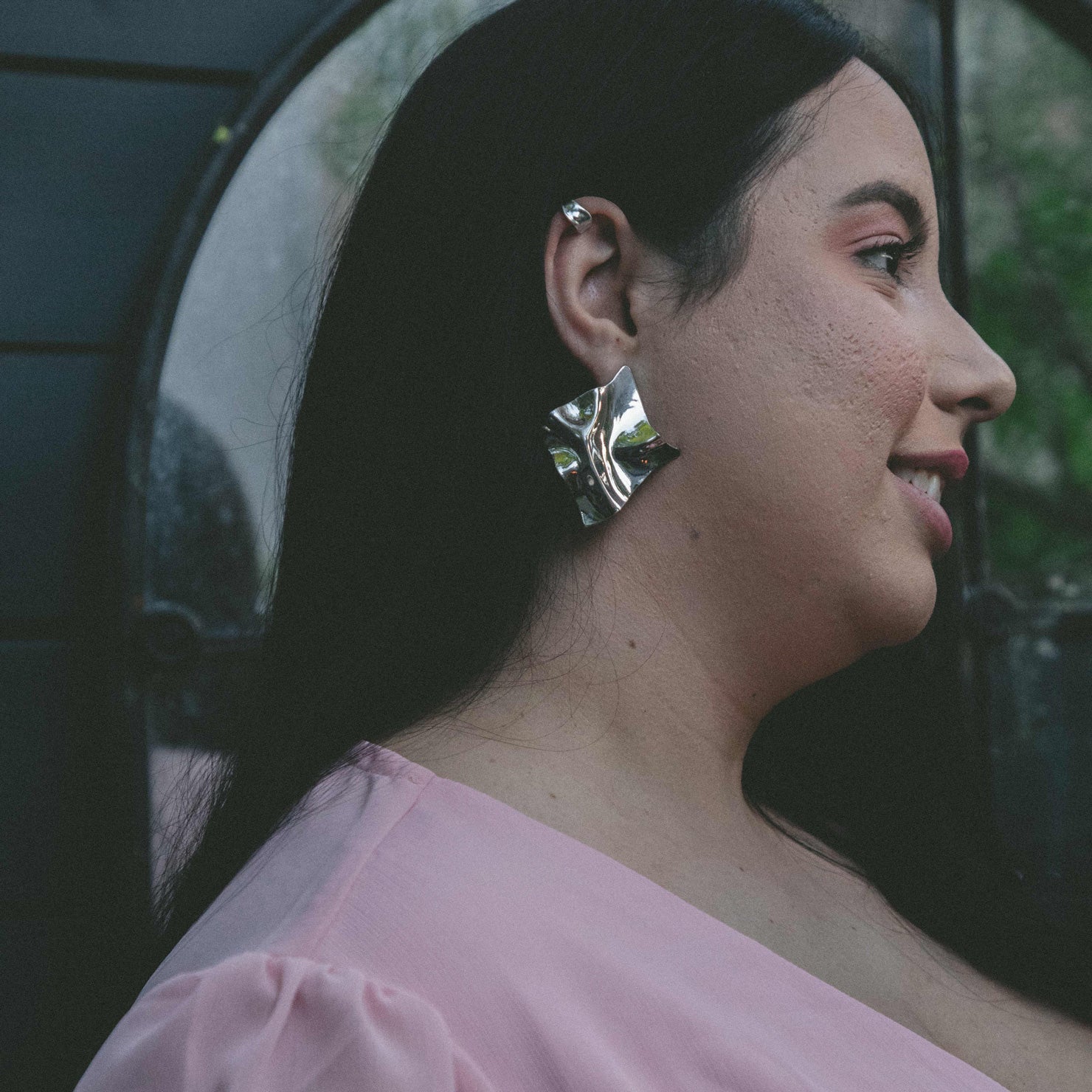 A model wearing the Aya Ear Cuff in Gold, made with 925 Sterling Silver for a timeless, luxurious style. Slip on these classy clip-on earrings to instantly elevate your look.