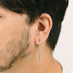 A model wearing Bar Clip On Earrings, designed to perfectly adorn those with slender and delicate ear lobes, the Bar Clip On Earrings are crafted from stainless steel for long-lasting shimmer and secured with a sliding spring-type closure.