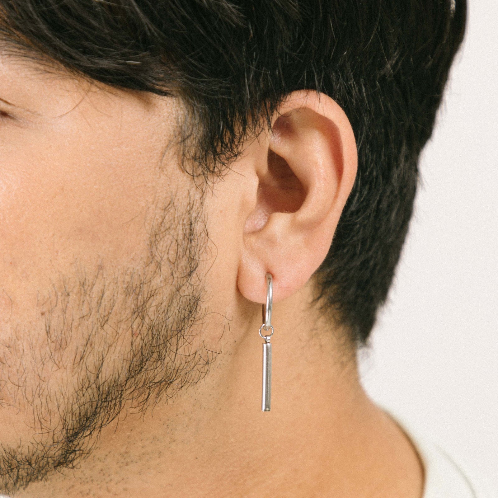 A model wearing Bar Clip On Earrings, designed to perfectly adorn those with slender and delicate ear lobes, the Bar Clip On Earrings are crafted from stainless steel for long-lasting shimmer and secured with a sliding spring-type closure.