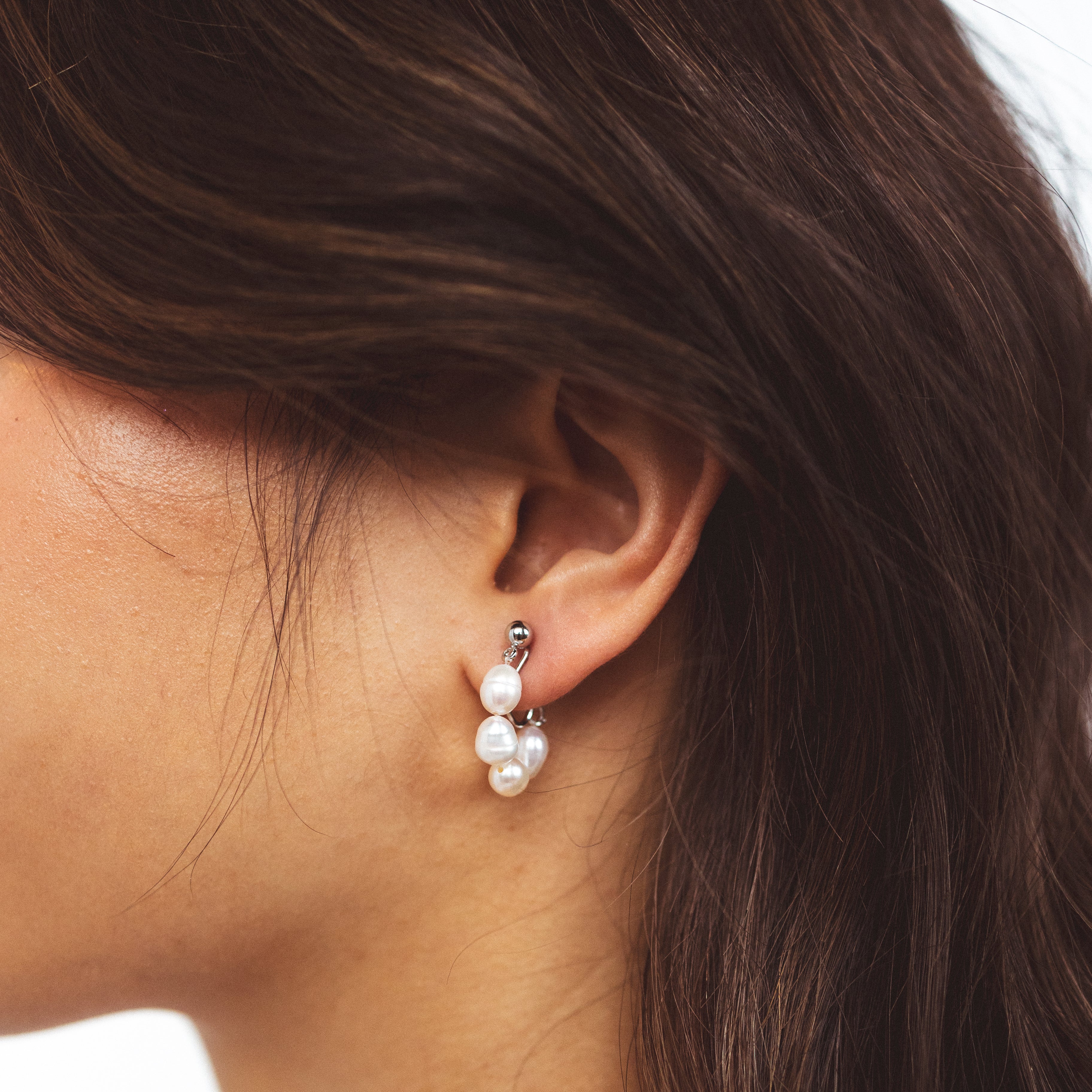 A model wearing the Blair Clip On Earrings. Our earrings offer a secure 24-hour hold and adjustable fit for all ear types, ideal for sensitive or stretched ears. Elevate your everyday ensemble with a touch of sophistication.
