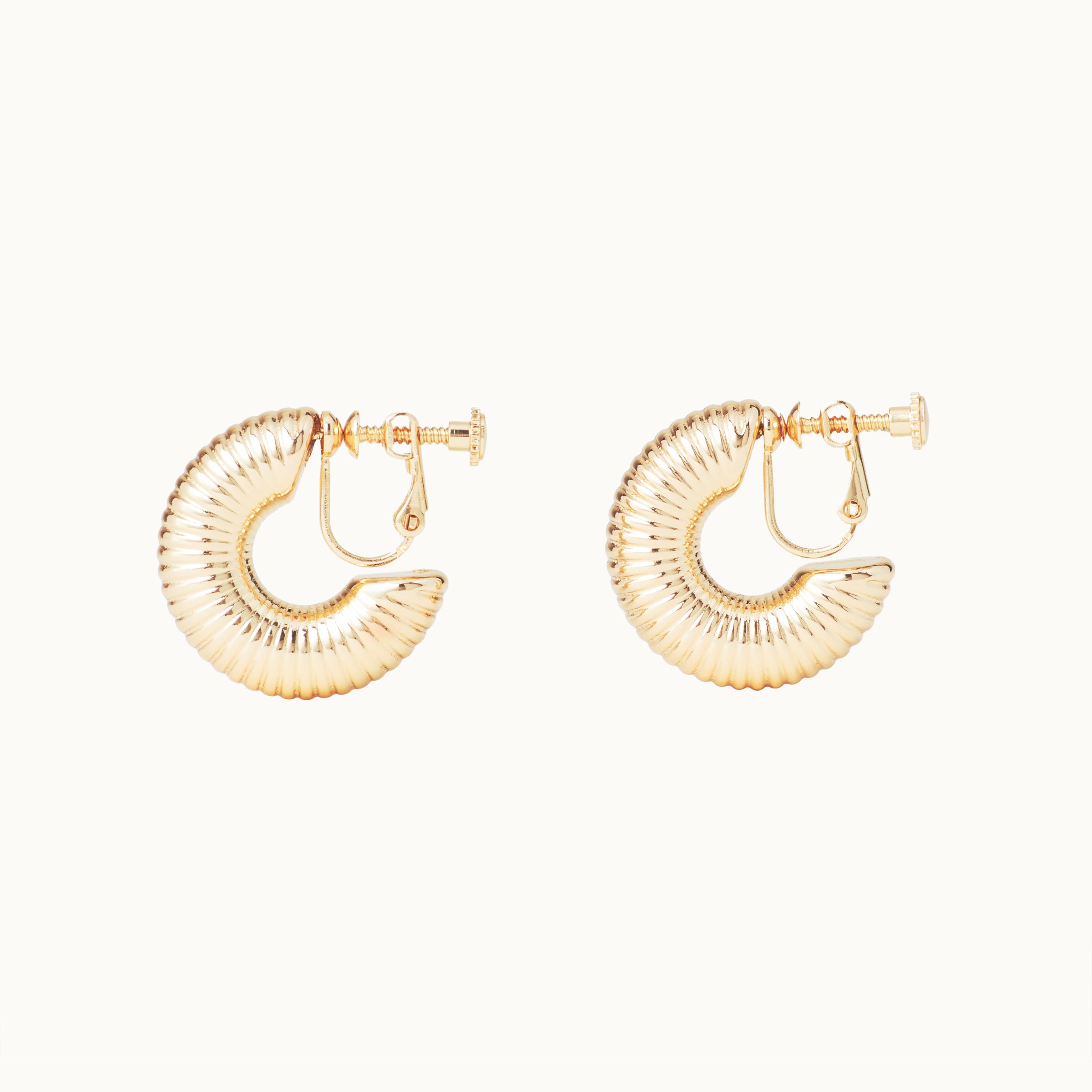 Image of the Bold Ribbed Hoop Clip On Earrings in Gold. Our screwback closure and manual adjustment capabilities cater to a wide range of needs, including thick, sensitive, small, and keloid-prone ears. Easily wear them for 8-12 hours for all-day fashion. Sold in pairs.