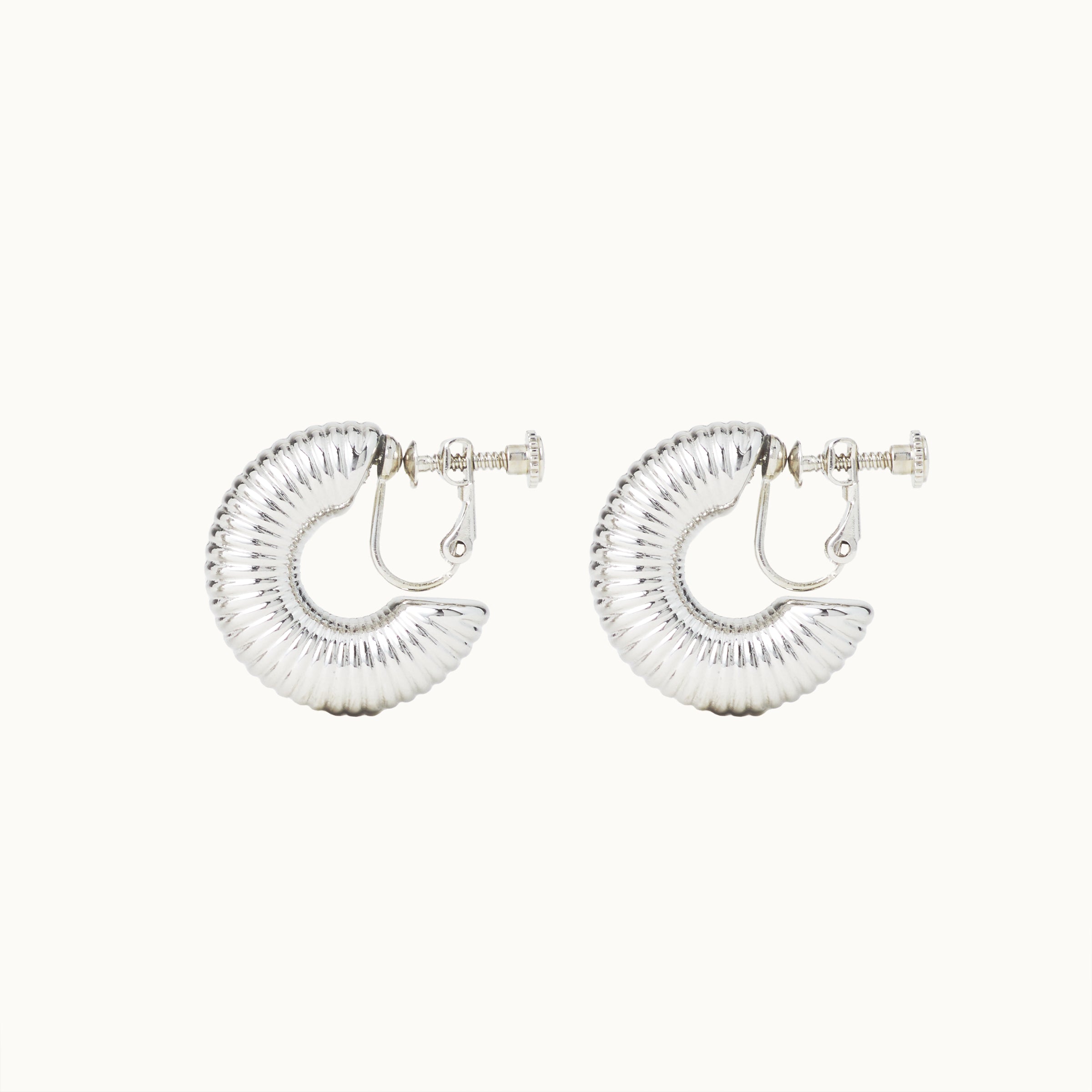 Image of the Bold Ribbed Hoop Clip On Earrings in Silver. Our screwback closure and manual adjustment capabilities cater to a wide range of needs, including thick, sensitive, small, and keloid-prone ears. Easily wear them for 8-12 hours for all-day fashion. Sold in pairs.