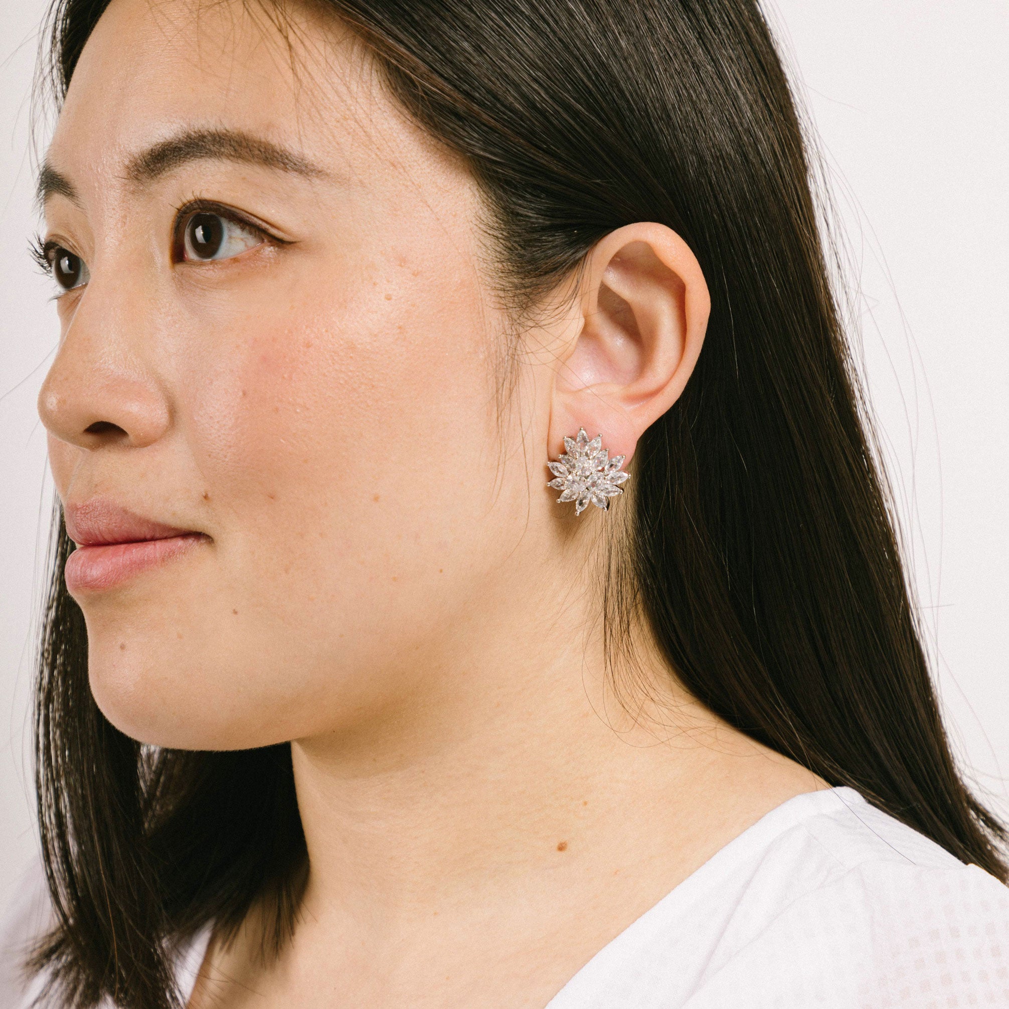 Model wearing chic silver plated clip-on earrings featuring a secure padded closure. Ideal for all ear types, including sensitive and stretched ears. These small silver clip-on earrings offer a comfortable wear duration of 8-12 hours. 