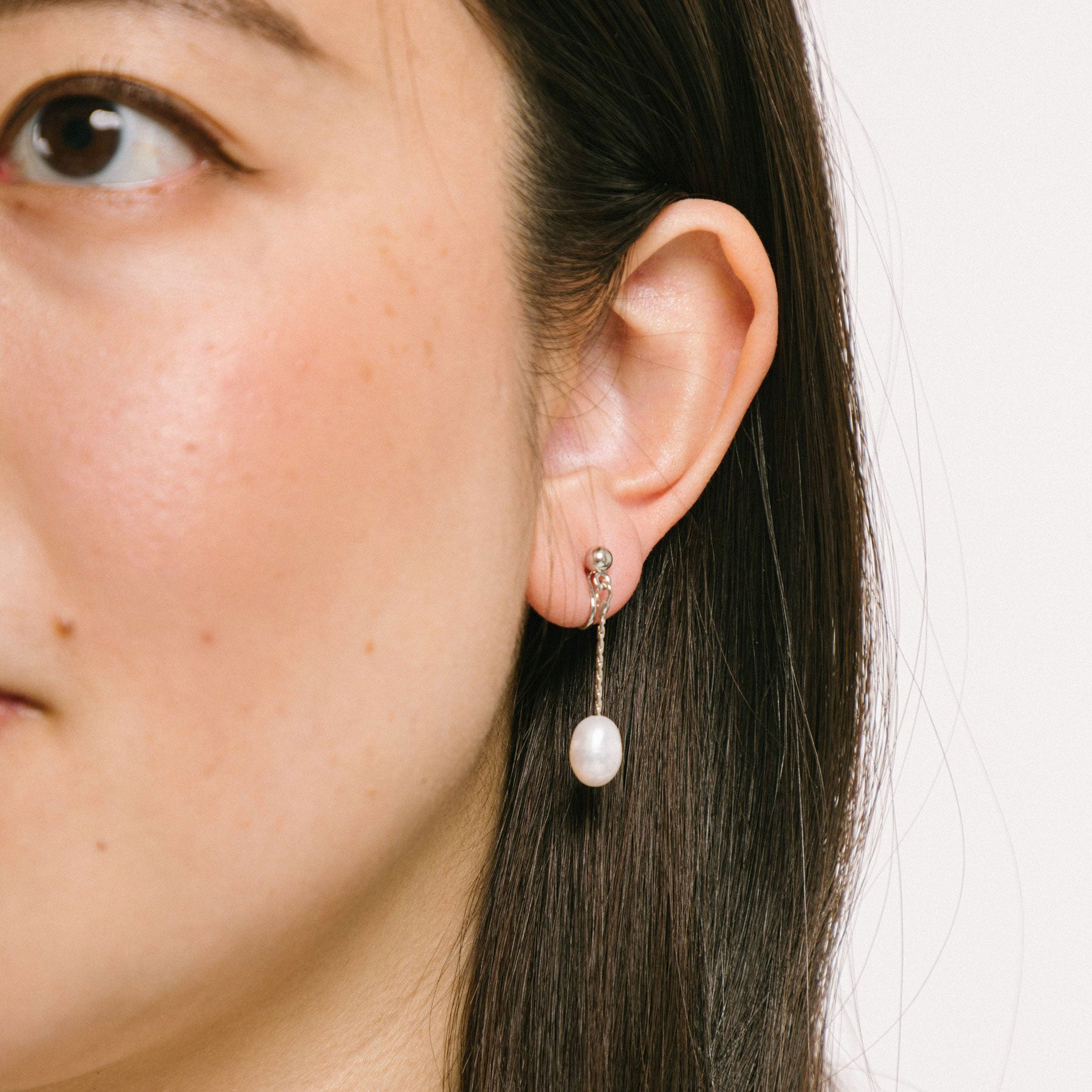 Timeless silver clip-on earrings crafted from silver-plated brass, embellished with lustrous freshwater pearls. Designed for all ear types, ensuring a comfortable 24-hour wear with a medium secure hold. 