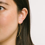 A model wearing the Scarlett Clip On Earrings offer a secure and comfortable mosquito coil clip-on closure. Perfect for those with thicker and larger ears, or those with sensitive ears, these earrings can be comfortably worn for up to 24 hours. The secure hold and ability to adjust with a gentle squeeze make them ideal for any occasion. Crafted with 14K Gold plating and free of Lead/Nickel/Cadmium, each order consists of one pair.