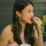 A model wearing the Claire Pearl Clip On Earrings in Gold bear Mosquito Coil Clip-Ons, offering a secure, comfortable fit for all types of ears - from Thick/Large to Sensitive, Small/Thin, and even Stretched/Healing - for up to 24 hours. Meticulously fashioned from 18K Gold plated metal alloy, Cubic Zirconia, and Simulated Faux Pearl, this chic design is Non-Tarnish and Water Resistant.