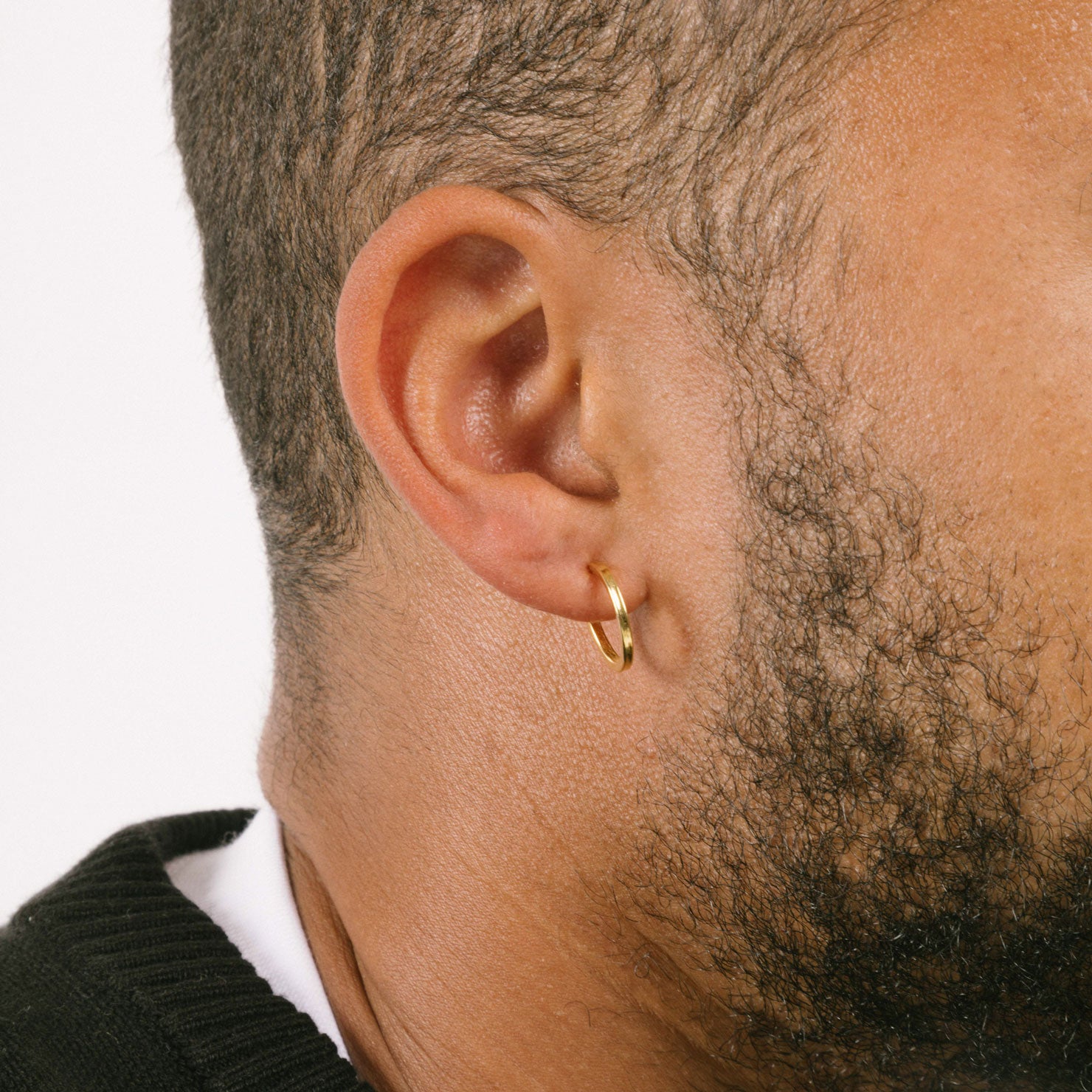 A model wearing the Classic Hoop Clip On Earrings feature a sliding spring closure that is ideal for small or thin ear lobes. The secure hold enables comfortable wear up to 4 hours, and the design automatically adjusts to the thickness of the ear. Crafted from stainless steel, the earrings come as a single pair.