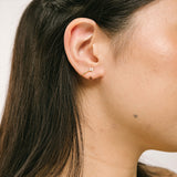 A model wearing our Gold Clover Ear Cuff, a chic and versatile accessory. Made from Gold or Silver Plated Copper alloy, this modern clover-shaped ear cuff features 4 sparkling Cubic Zirconia stones. Ideal for both the nose and ear, it effortlessly adds sophistication to any outfit, allowing you to adorn yourself with style and flair.