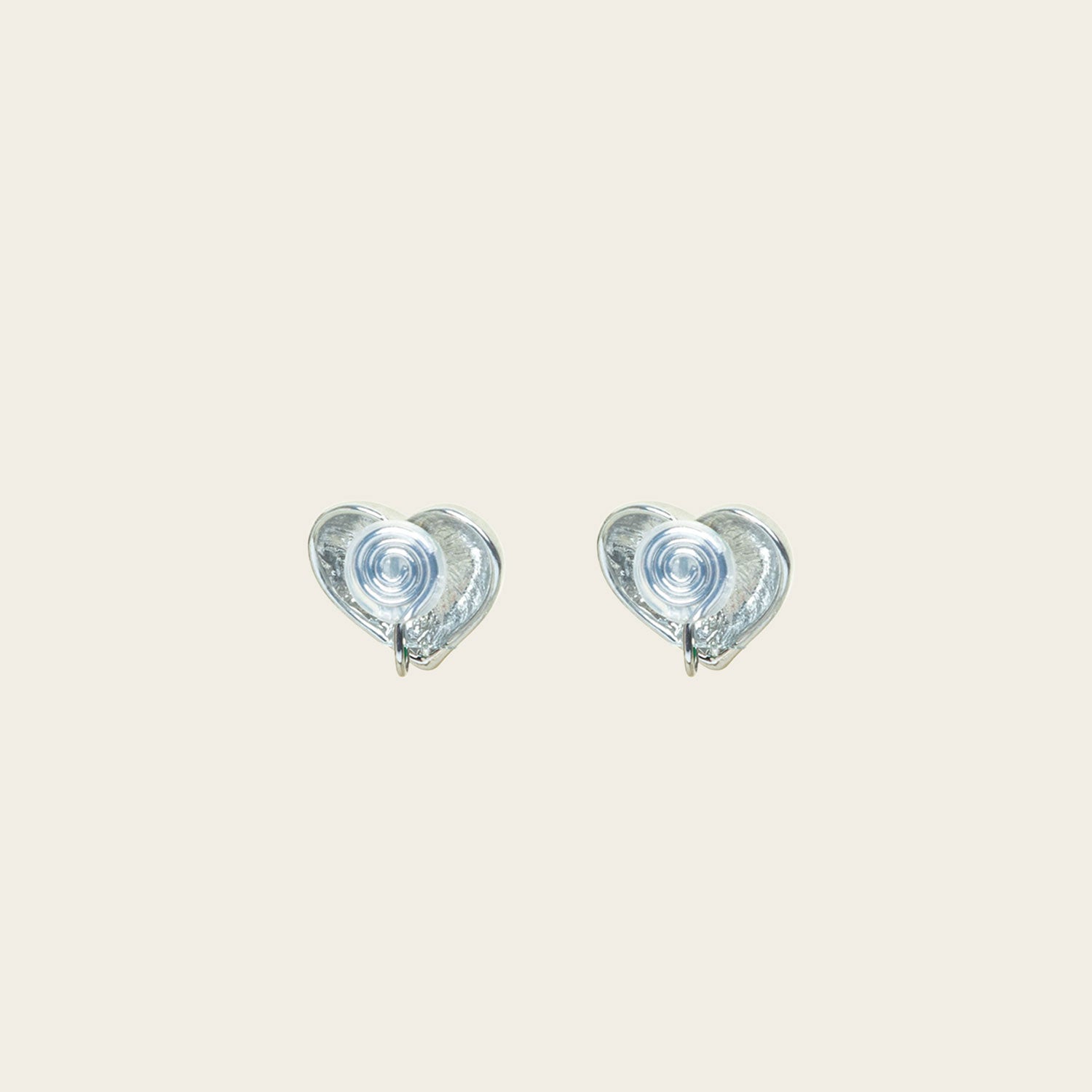 Image of the Coeur Clip On Earrings in Silver offer a medium-strength, adjustable hold via a mosquito coil clip. Ideal for all ear types, these earrings provide a secure yet comfortable fit for up to 24 hours. Crafted with Zinc Alloy and Copper, each purchase contains a single pair.