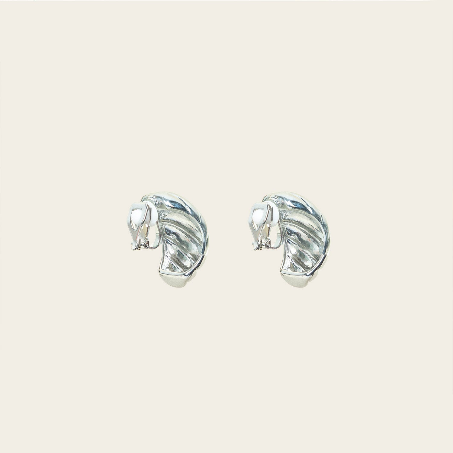 Image of the Croissant Dome Clip On Earrings in Silver are designed to provide a secure fit for all ear types. The rubber padding has a comfortable wear duration of 8-12 hours and is made with a Gold Tone Zinc Alloy. This item includes one pair.