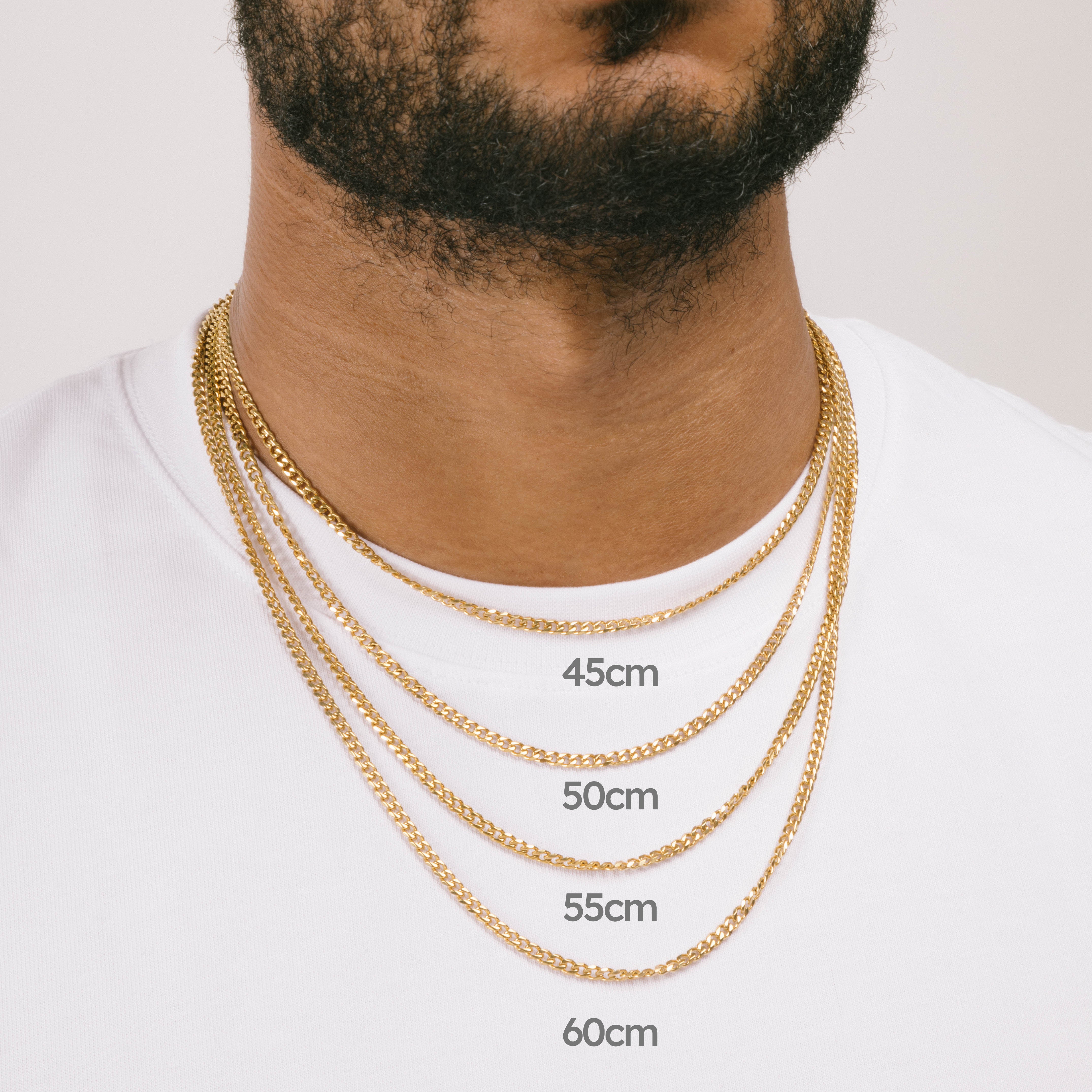A model wearing the Cuban Chain in Gold is crafted from 18K Gold Plated material and is non-tarnish, water-resistant, and designed to be hypoallergenic.