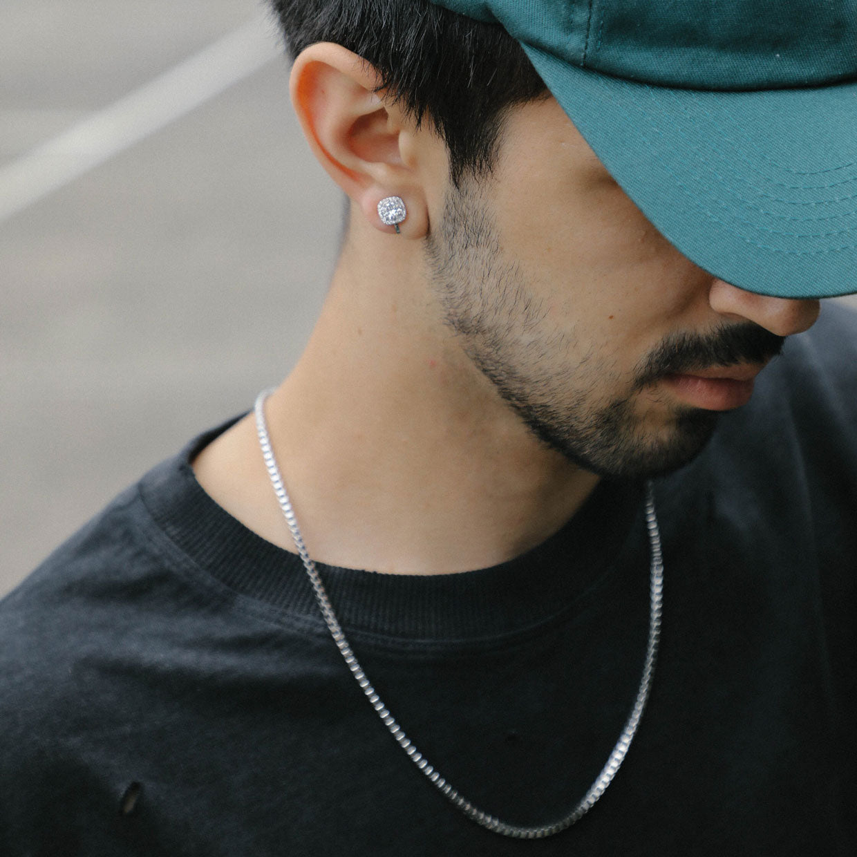 A model wearing the Cushion Stud Clip-On Earrings in Silver boast a padded closure type and are suited for all types of ears. With secure hold and comfortable wear duration of up to 8-12 hours, this one pair of earrings is crafted from gold plated copper and finished with Cubic Zirconia.