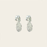 Image of the Daiquiri Drop Clip On Earrings in Silver feature a secure, padded clip-on closure ideal for all ear types, offering up to 12 hours of comfortable wear. Crafted from Zinc and Copper alloy, these earrings come as a single pair with removable rubber padding.