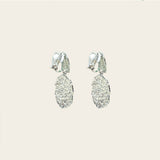 Image of the Daiquiri Drop Clip On Earrings in Silver feature a secure, padded clip-on closure ideal for all ear types, offering up to 12 hours of comfortable wear. Crafted from Zinc and Copper alloy, these earrings come as a single pair with removable rubber padding.