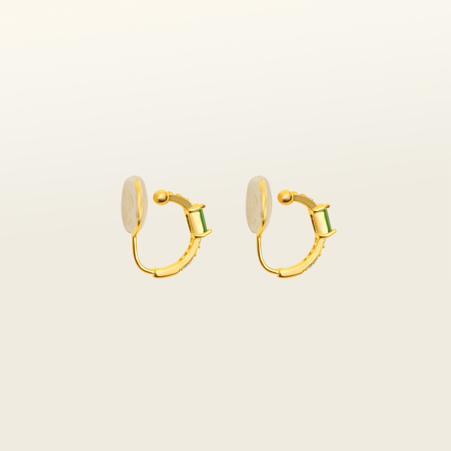 Image of the Emerald Pavé Huggie Clip-On Earrings features a closure type of mosquito coil clip-on earrings. They are suitable for all types of ear shapes and sizes, and are comfortable to wear for up to 24 hours. The hold strength is medium, allowing you to gently adjust the padding forward once on the ear. Crafted with 18k gold plated metal alloy and cubic zirconia, these earrings are non-tarnish and water-resistant.