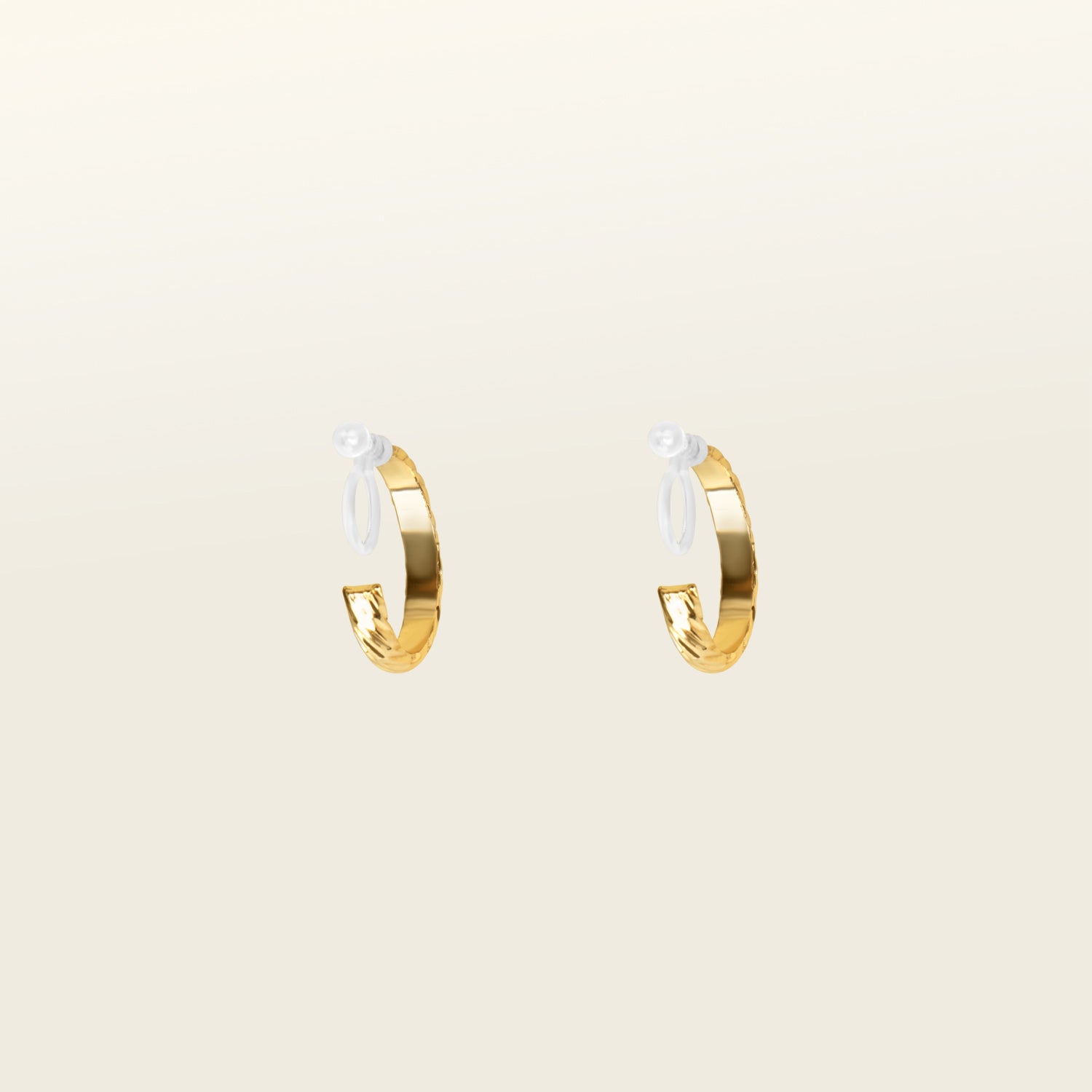 Image of the Gold Talia Hoop Clip-On Earring features a resin clip-on closure that is ideal for all ear types, providing a medium secure hold and an average comfortable wear duration of 8-12 hours. It is not adjustable, and is also available in Silver. The earrings are constructed with a gold tone metal alloy.