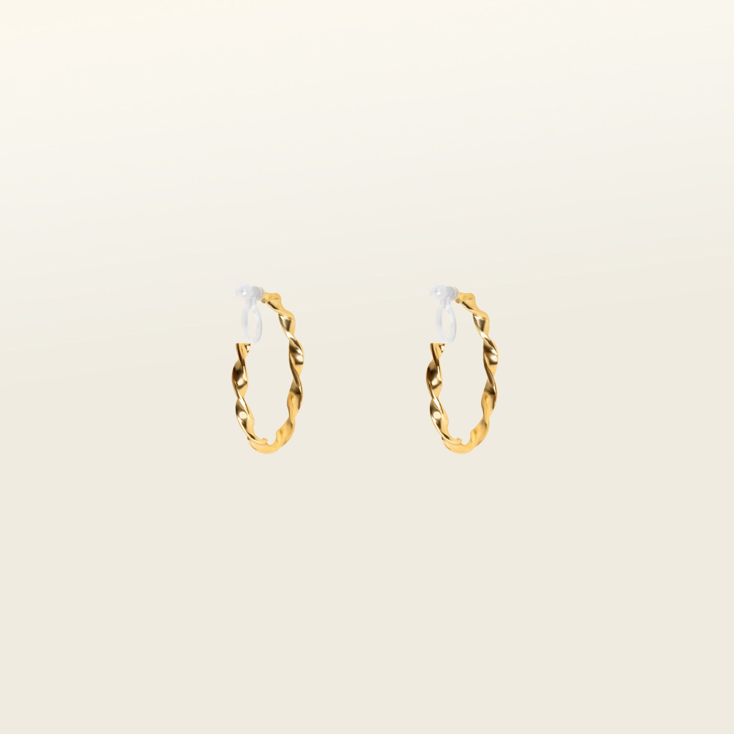 Image of the Gold Wave Hoop Clip-On Earrings boast a closure type of resin clip-on, ideal for the vast majority of ear types. Average wear duration ranges from 8-12 hours, offering medium secure hold with no ability to adjust. Crafted from gold tone metal alloy, this item comes as one pair and is also available in silver.