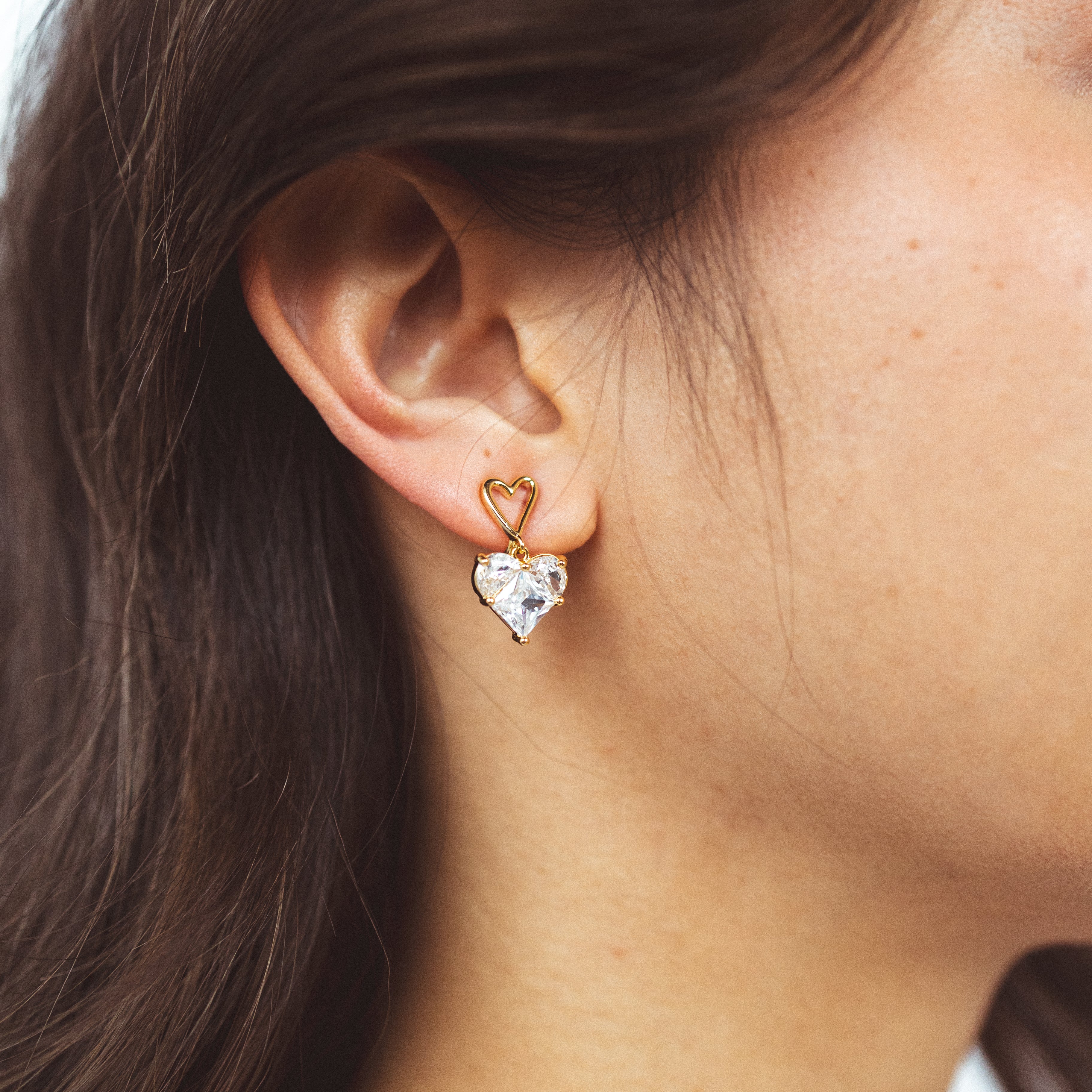 A model wearing the Grace Clip On Earrings feature a unique Mosquito Coil Clip-On Closure and adjustable padding. Ideal for various ear types, including thick, sensitive, small, stretched, or keloid-prone ears. Don't leave home without this stylish and practical accessory for a secure 24-hour wear option.