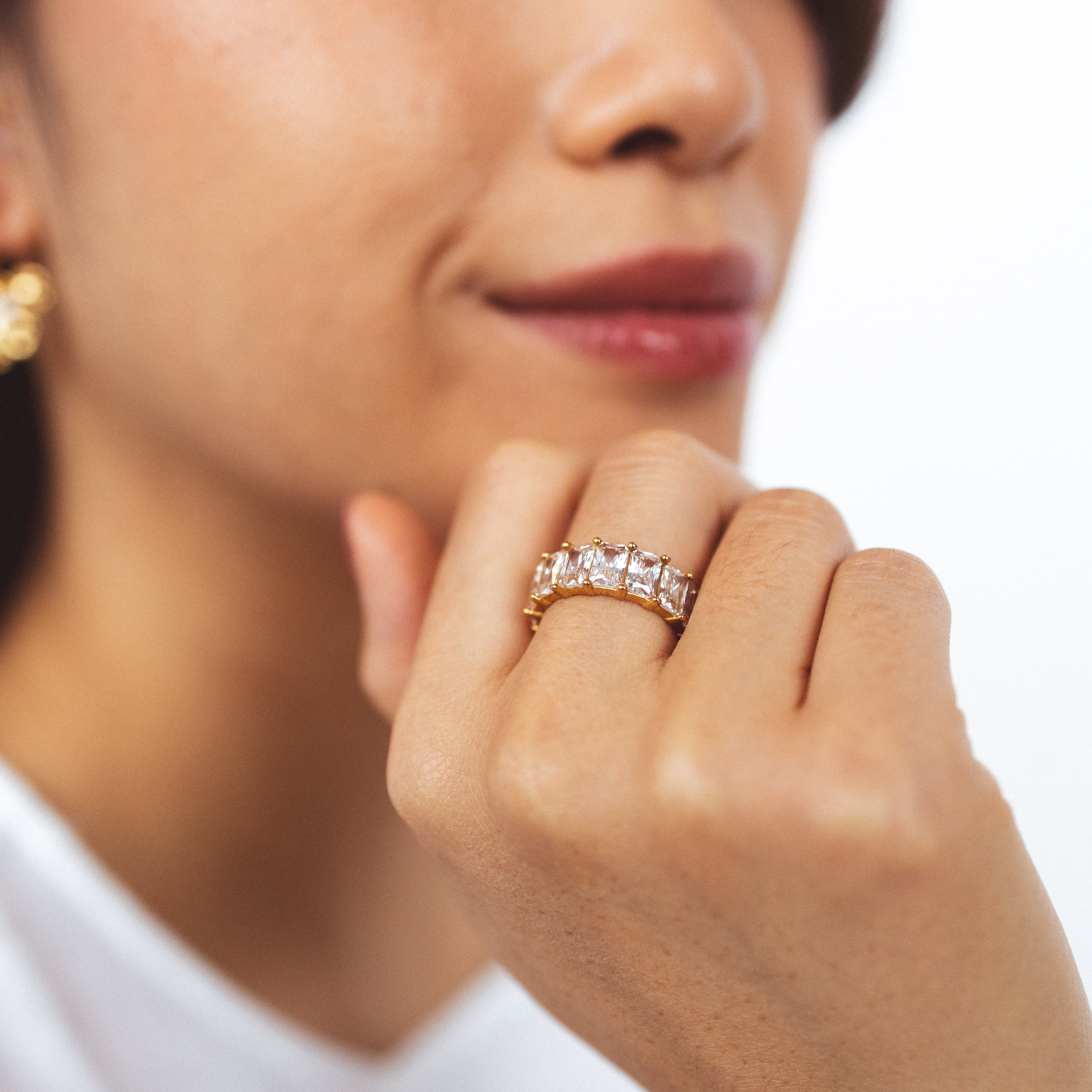 A model wearing the Jamie Ring boasts 18K gold plating over durable stainless steel for unrivaled resistance to tarnishing and water damage. Its sleek and timeless appeal is heightened by the non-adjustable design, making it the perfect single ring for any occasion.
