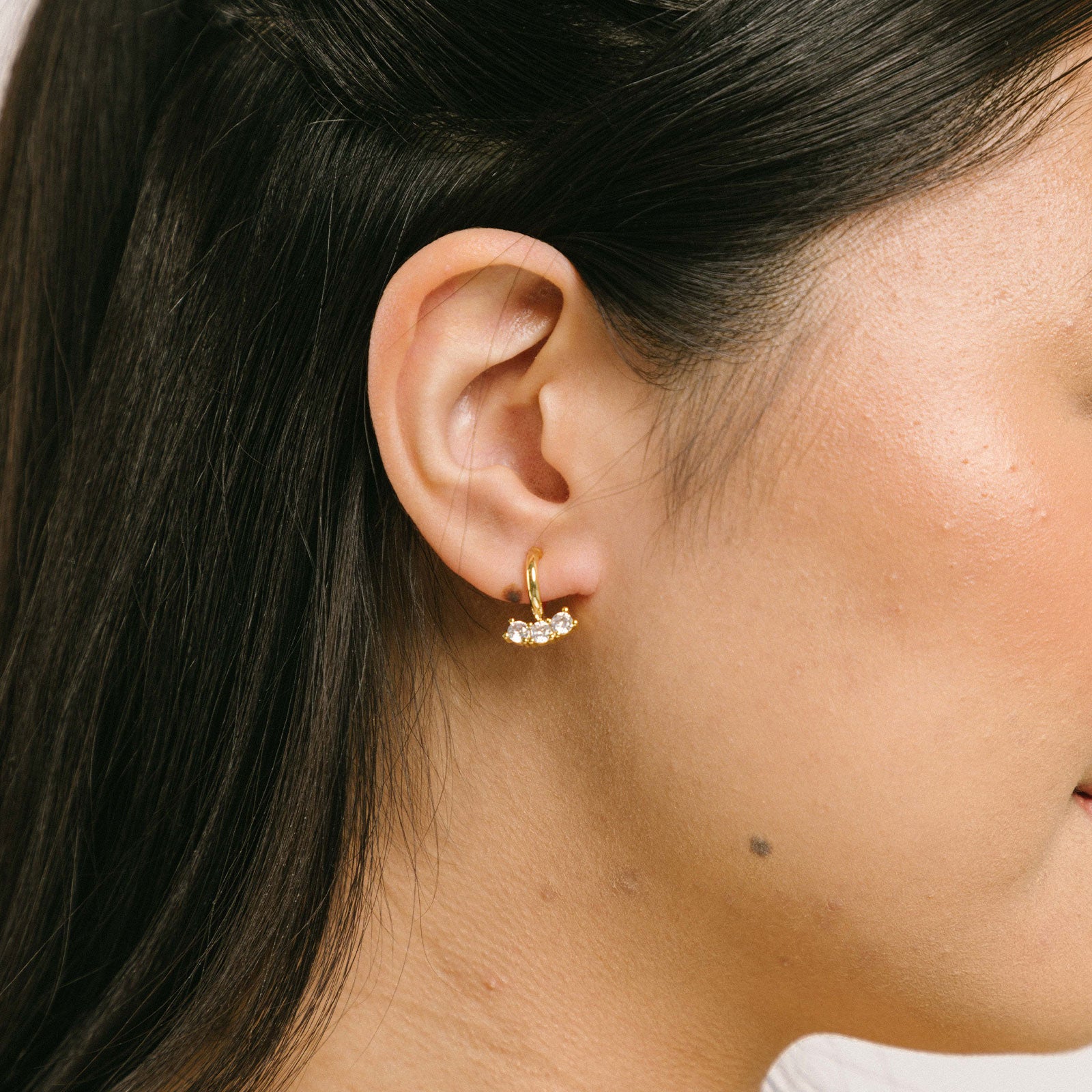 A model wearing the Juliette Clip-On Earrings offer a medium-strength, secure hold that lasts 24 hours. Easily adjustable with a gentle squeeze, these Mosquito Coil Clip-Ons are ideal for thick/large ears as well as sensitive ears. Crafted with gold-tone plated metal alloy and cubic zirconia, this item is sold as a single pair.
