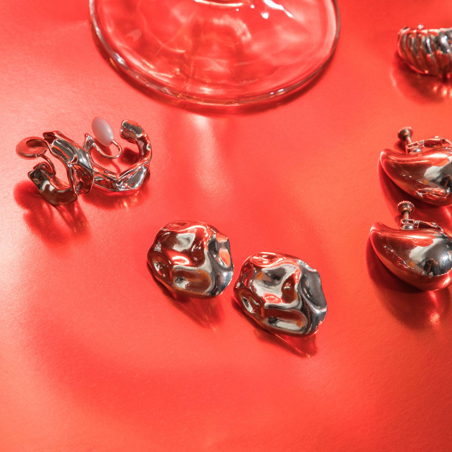 A model wearing the Amaya Clip On Earrings in Silver feature a secure padded clip-on closure type, making them suitable for all ear types.The average comfortable wear duration is 8-12 hours, and the Copper Alloy construction ensures a reliable and secure hold. The item is sold as one pair; adjustable rubber padding is included.