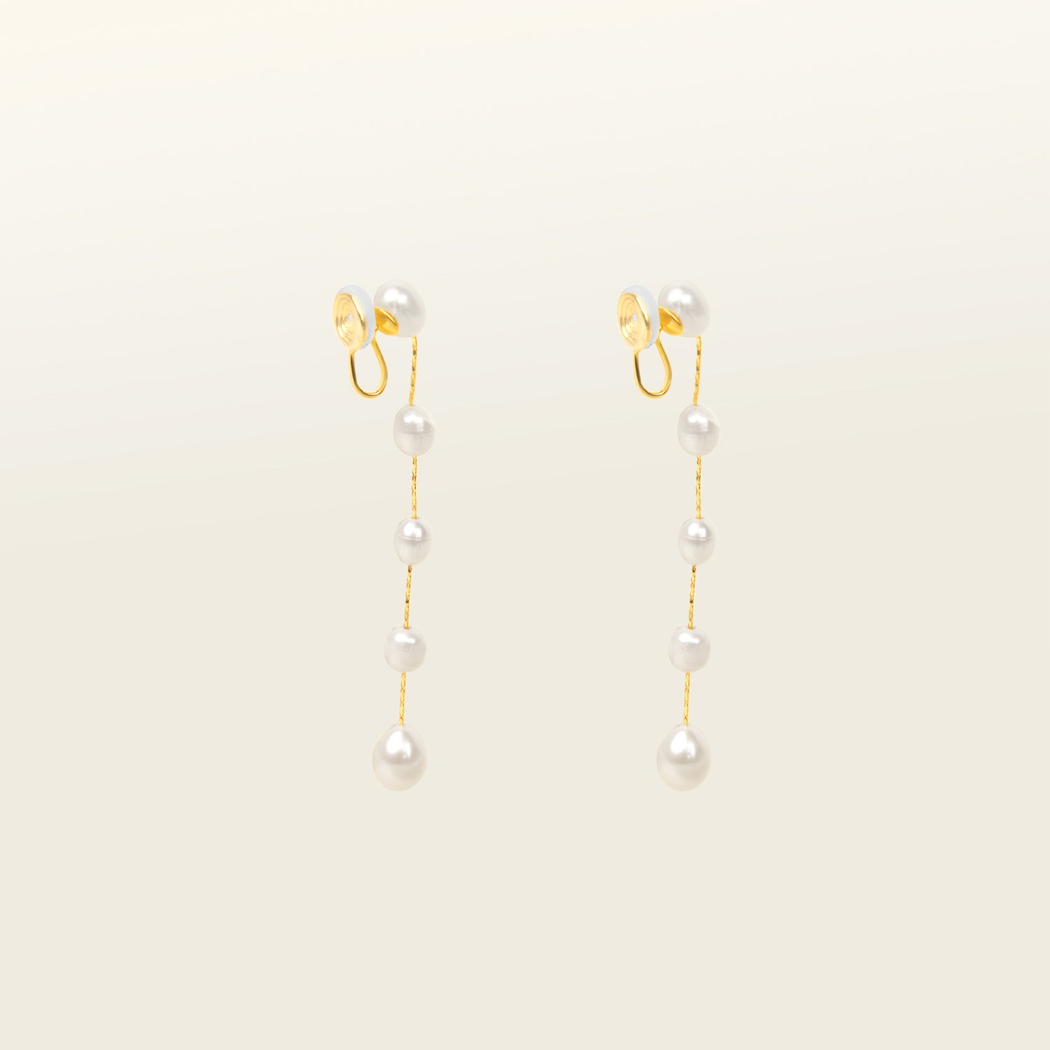 Image of the Lune Pearl Clip-On Earrings in Gold feature a unique, secure mosquito coil clasp. They are ideal for all ear types, from thick and large ears to sensitive and small. With medium hold strength, the earrings can be comfortably worn up to 24 hours and easily adjusted. Crafted with freshwater pearls, each pair may display natural variations in size and color. Materials include freshwater pearl and 18K gold-plated stainless steel.