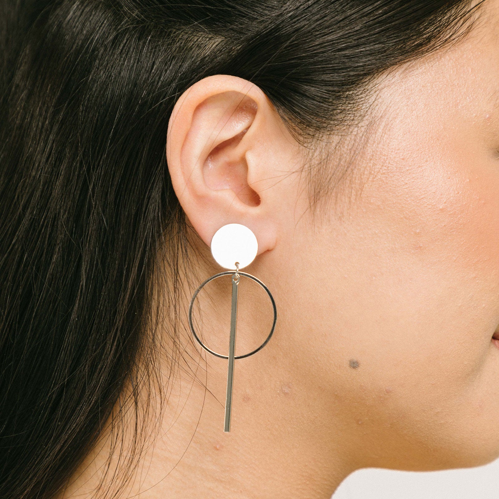 A model wearing the Melissa Clip-On Earrings offer a secure hold, with an average comfortable wear duration of 8-12 hours. The closure type is padded for a secure fit that accommodates all ear types, including thick/large ears, sensitive ears, small/thin ears, and stretched/healing ears. Constructed from gold tone/silver tone plated zinc alloy, each pair includes removable rubber padding.