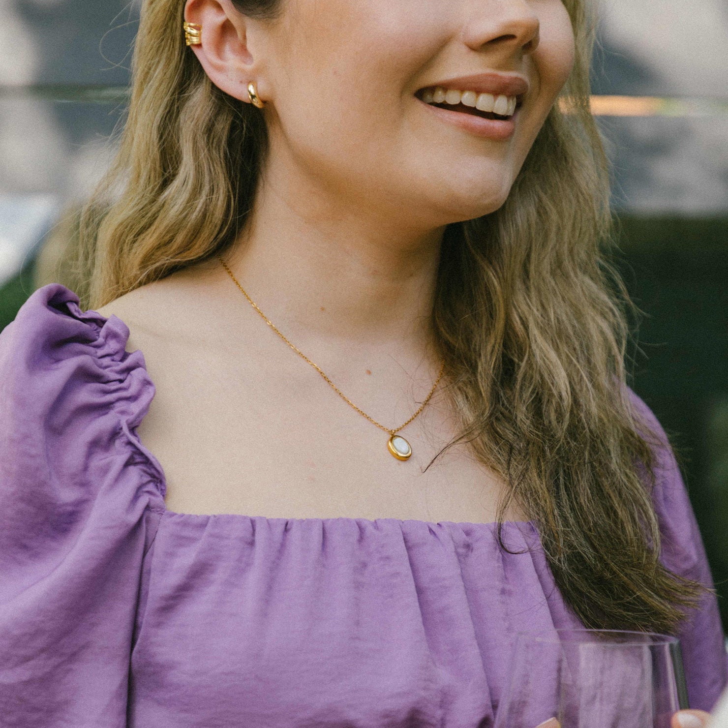 A model wearing the Mother of Pearl Pendant Necklace is crafted from 18K Gold Plated over Stainless Steel and is both non-tarnish and waterproof - perfect for everyday wear. For an added touch, pair the necklace with its sister Celestial Ring for the complete, stunning look.